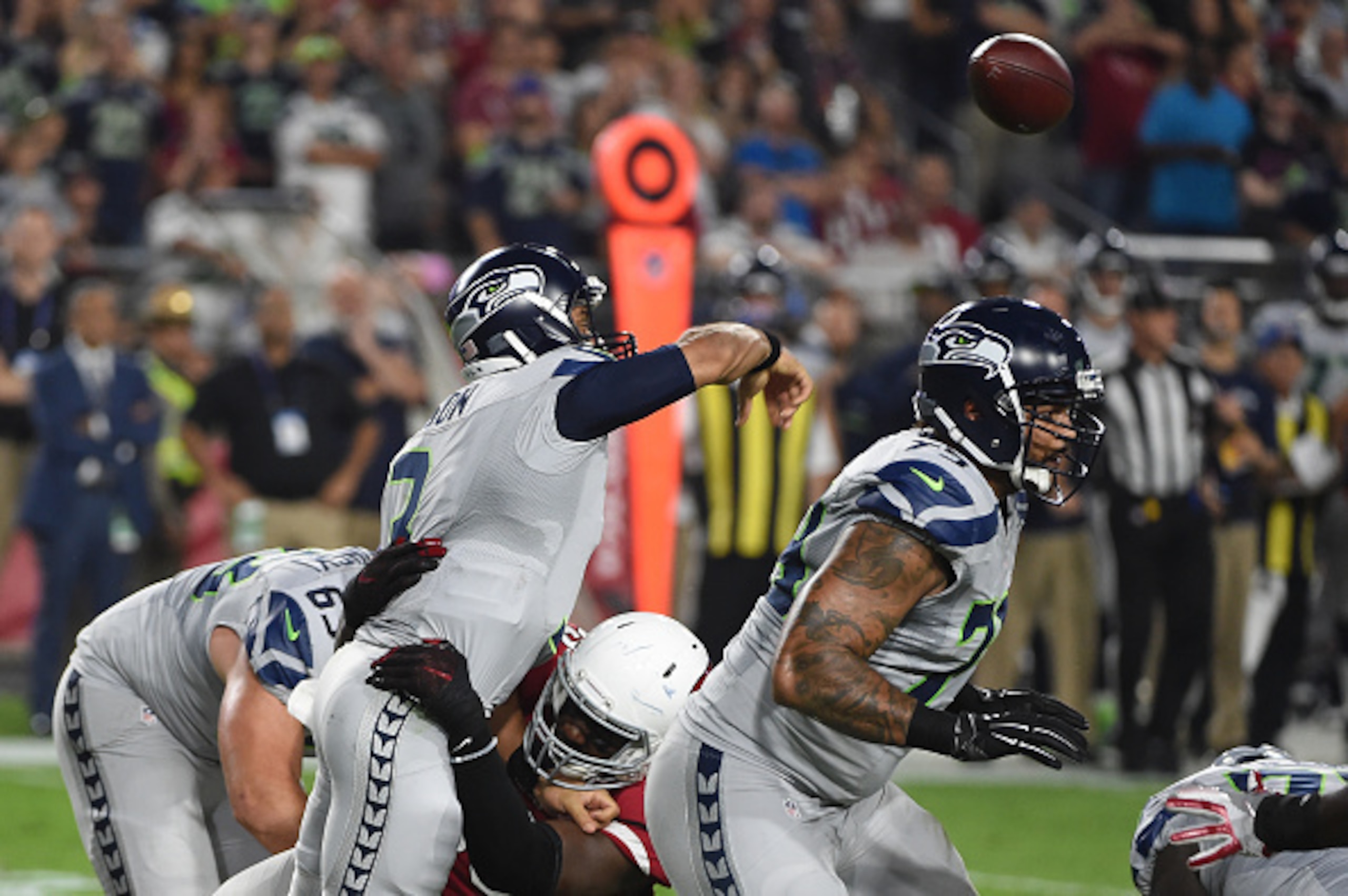 GLENDALE, AZ - OCTOBER 23:  Quarterback Russell Wilson #3 of the Seattle Seahawks is tackled by Arizona Cardinals defense while making a pass during the first half of the NFL game at University of Phoenix Stadium on October 23, 2016 in Glendale, Arizona. 