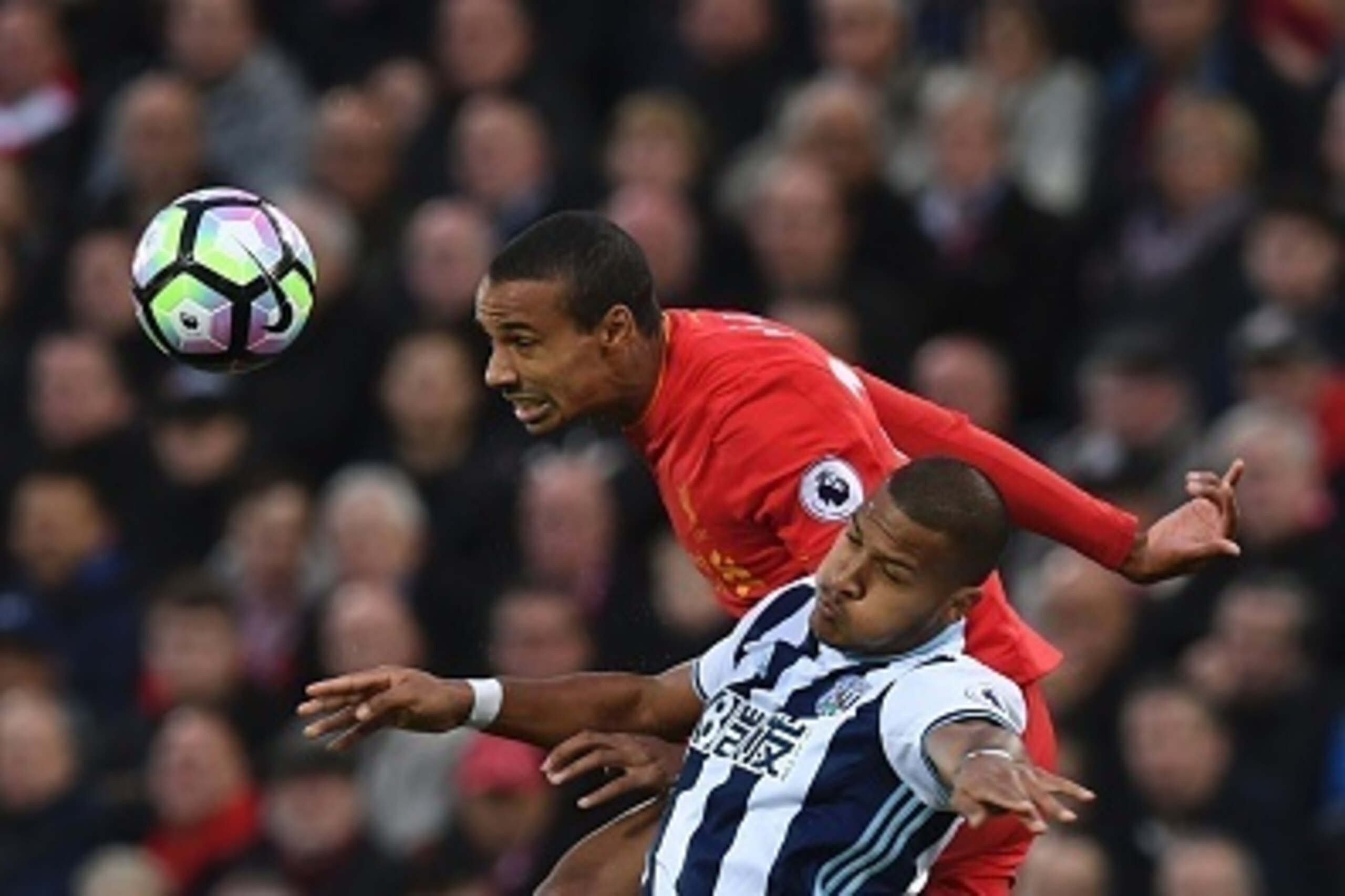 Liverpool's German-born Cameroonian defender Joel Matip (top) beats West Bromwich Albion's Venezuelan striker Salomon Rondon (bottom) in the air during the English Premier League football match between Liverpool and West Bromwich Albion at Anfield in Live