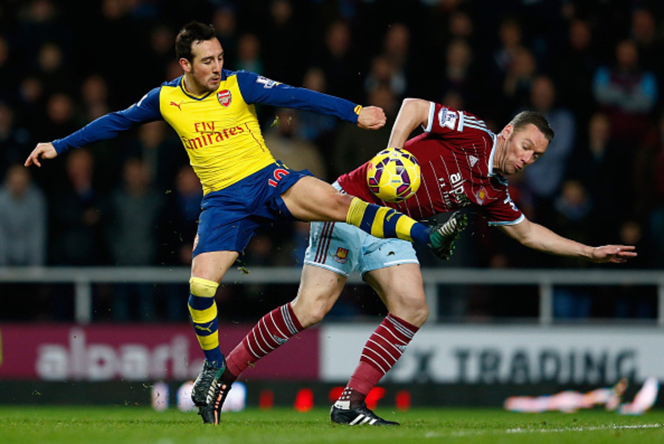 LONDON, ENGLAND - DECEMBER 28:  Santi Cazorla of Arsenal battles with Kevin Nolan of West Ham United during the Barclays Premier League match between West Ham United and Arsenal at Boleyn Ground on December 28, 2014 in London, England.  (Photo by Julian F