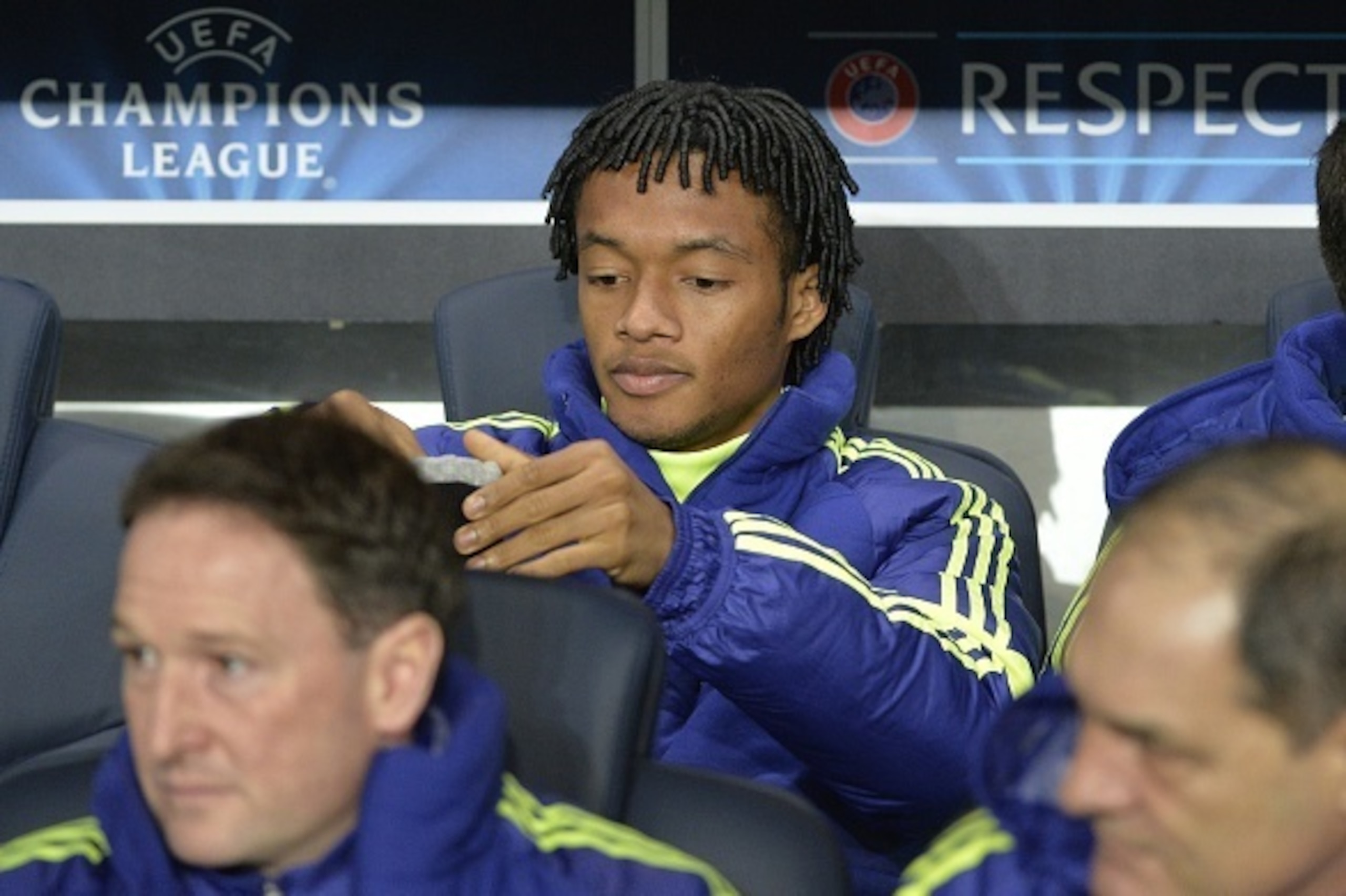 Chelsea's new Colombian midfielder Juan Cuadrado sits on the bench ahead of the UEFA Champions League round of 16 football match between Paris Saint-Germain (PSG) and Chelsea at the Parc des Princes stadium in Paris on February 17, 2015.  AFP PHOTO / MIGU