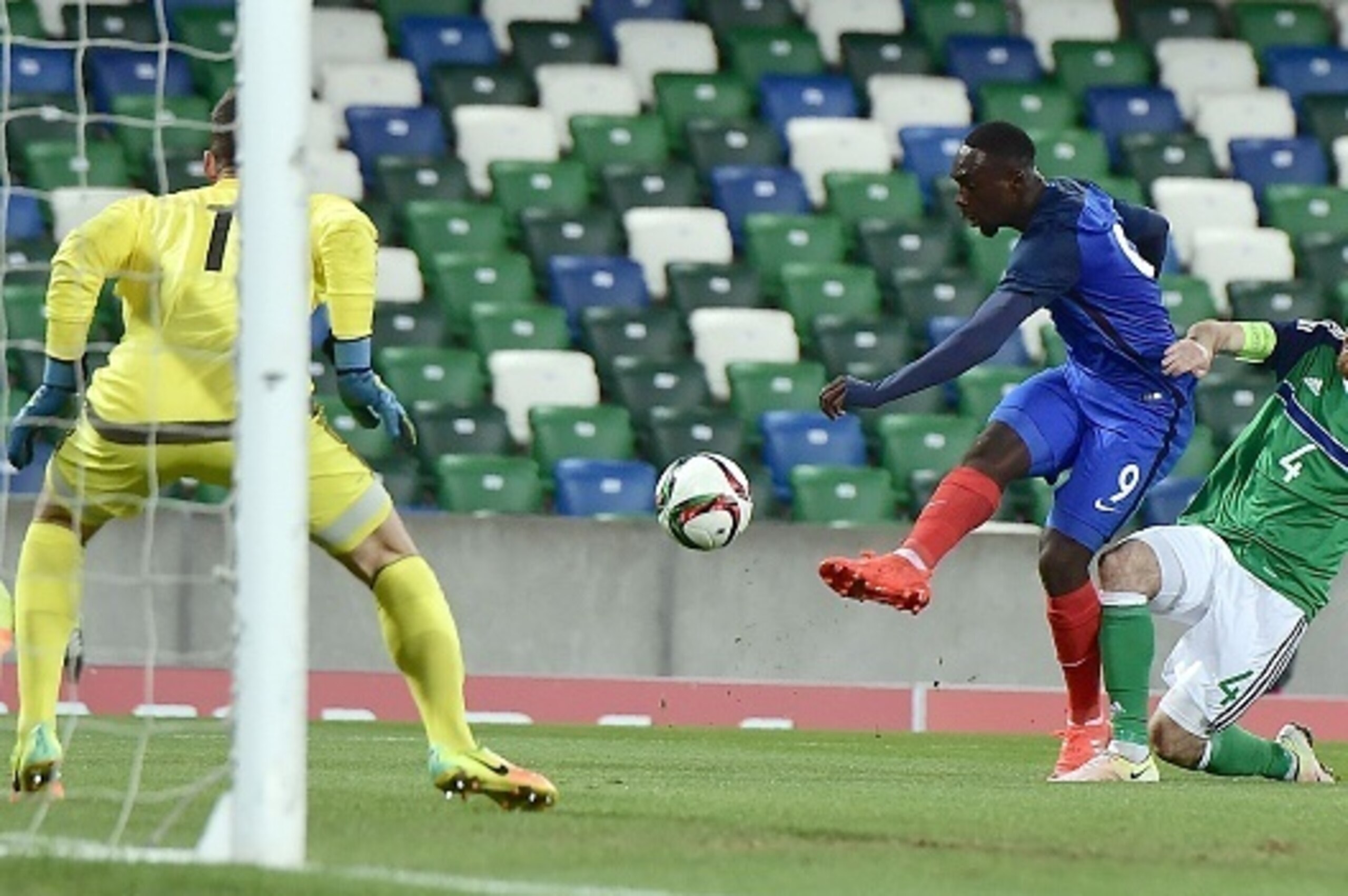 France's forward Jean-Kevin Augustin (C) shots to score the team's second goal past Northern Ireland's goalkeeper Conor Mitchell (L) and Northern Ireland's defender Liam Donnelly during the Under-21 2017 European Championship qualifier football match betw