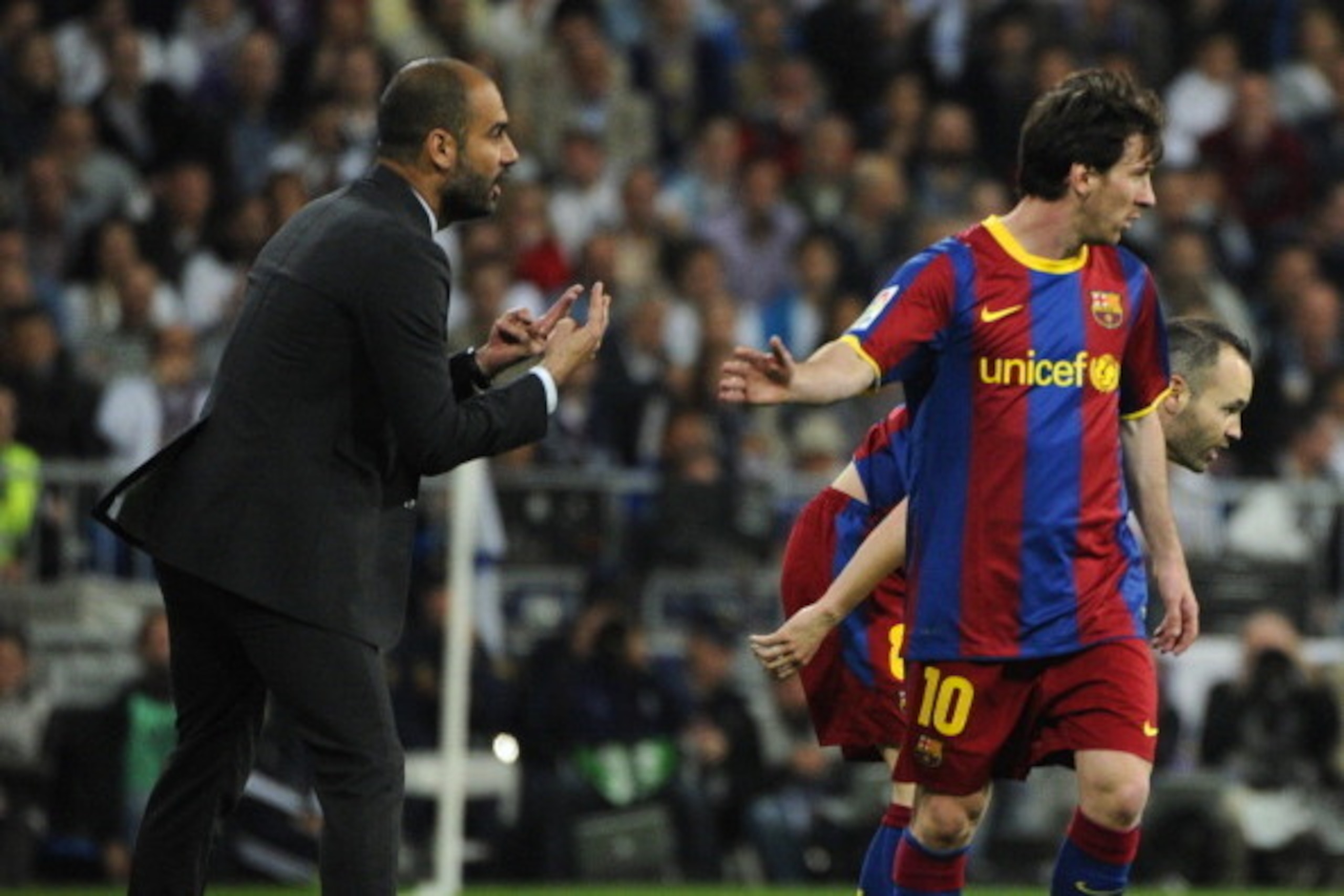 Barcelona's coach Josep Guardiola (L) speaks with Barcelona's Argentinian forward Lionel Messi (R) during 'El Clasico' Spanish League football match Real Madrid against Barcelona at the Santiago Bernabeu stadium in Madrid, on April 16, 2011. AFP PHOTO/JAV