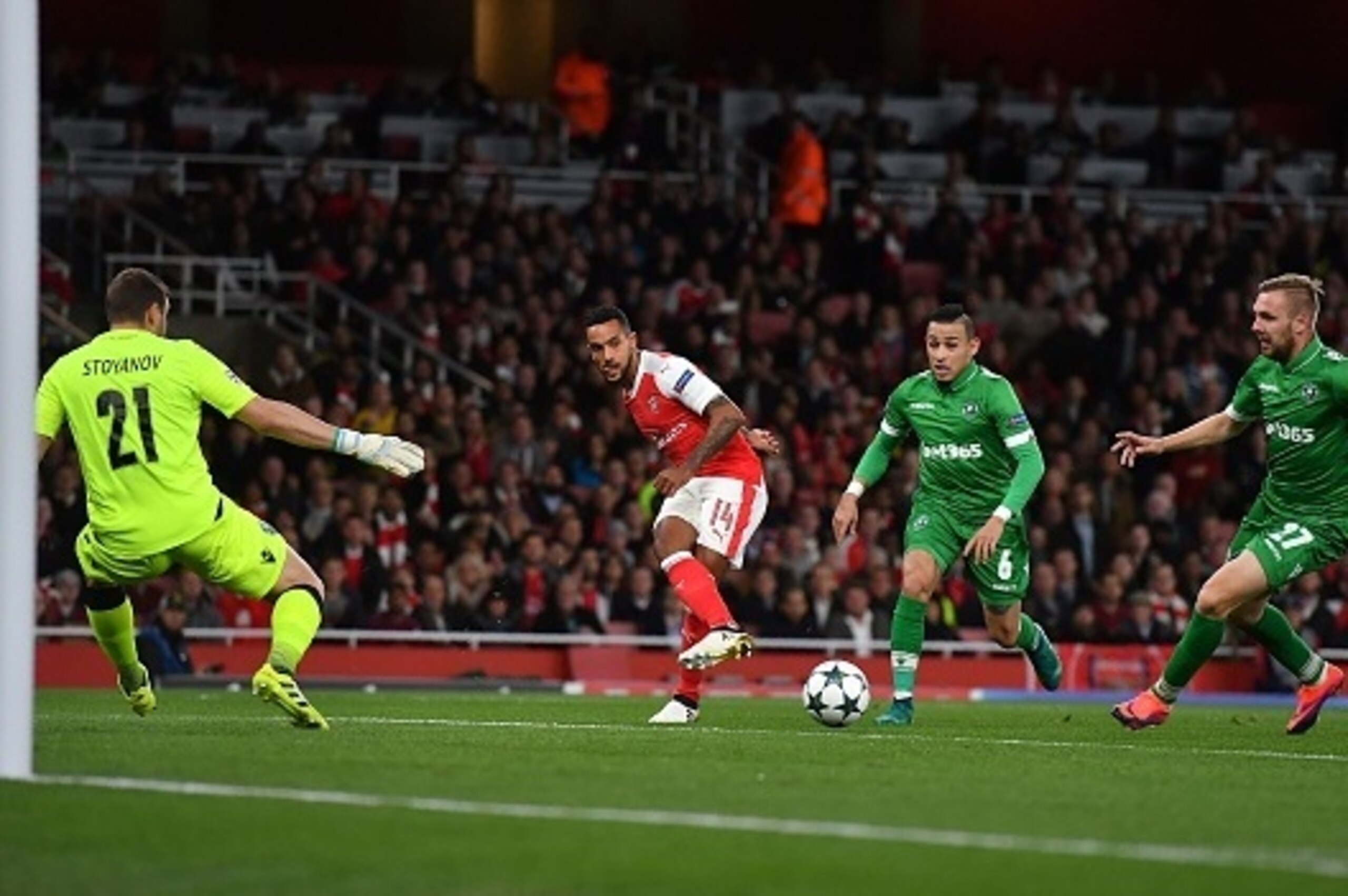 Arsenal's English midfielder Theo Walcott (C) attempts to cross the ball to Arsenal's Chilean striker Alexis Sanchez (unseen) in front of Ludogorets' Bulgarian goalkeeper Vladislav Stoyanov (L) during the UEFA Champions League Group A football match betwe