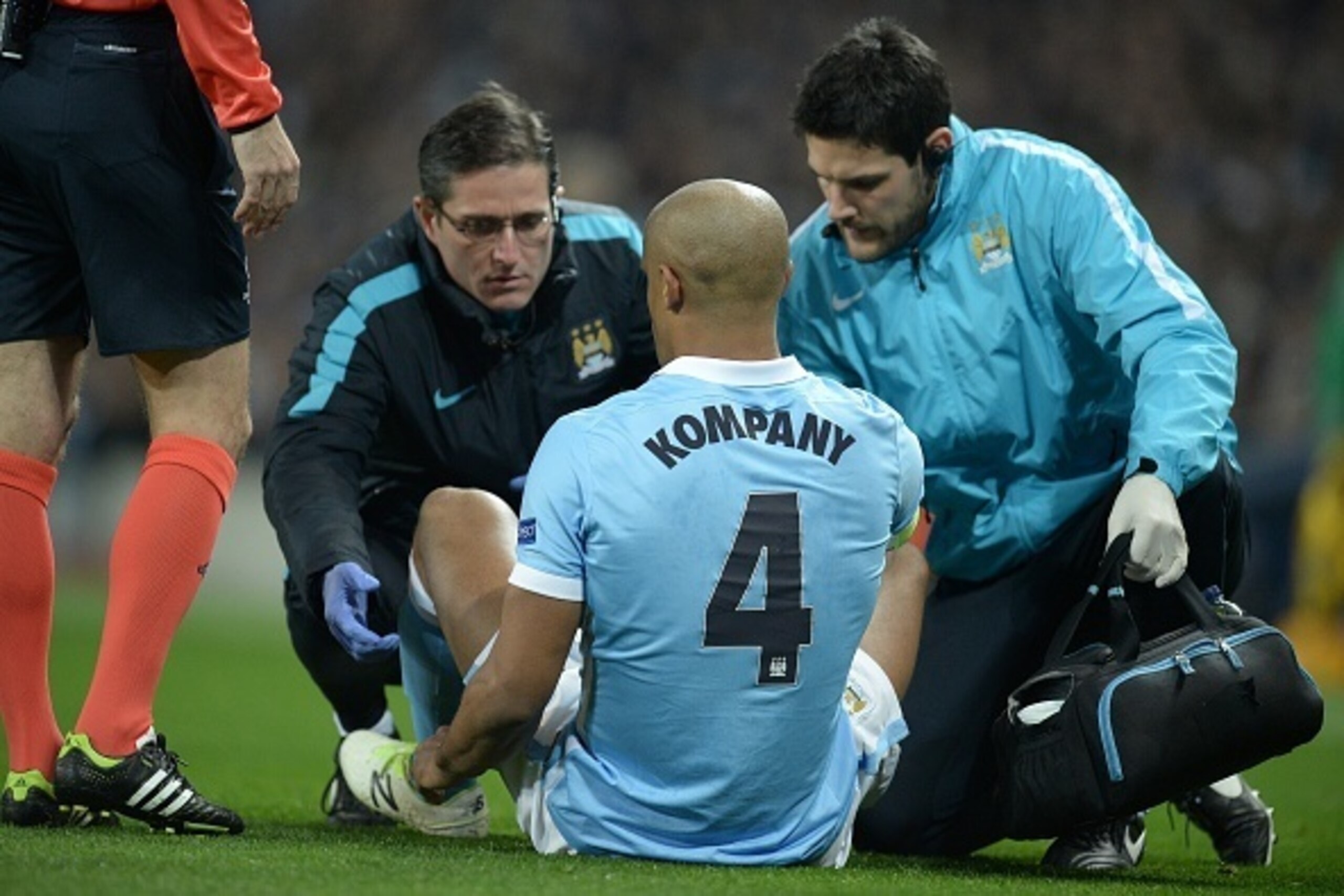Manchester City's Belgian defender Vincent Kompany receives medical treatment before leaving the pitch injured during a UEFA Champions League last 16, second leg football match between Manchester City and Dynamo Kiev at the Etihad Stadium in Manchester, n