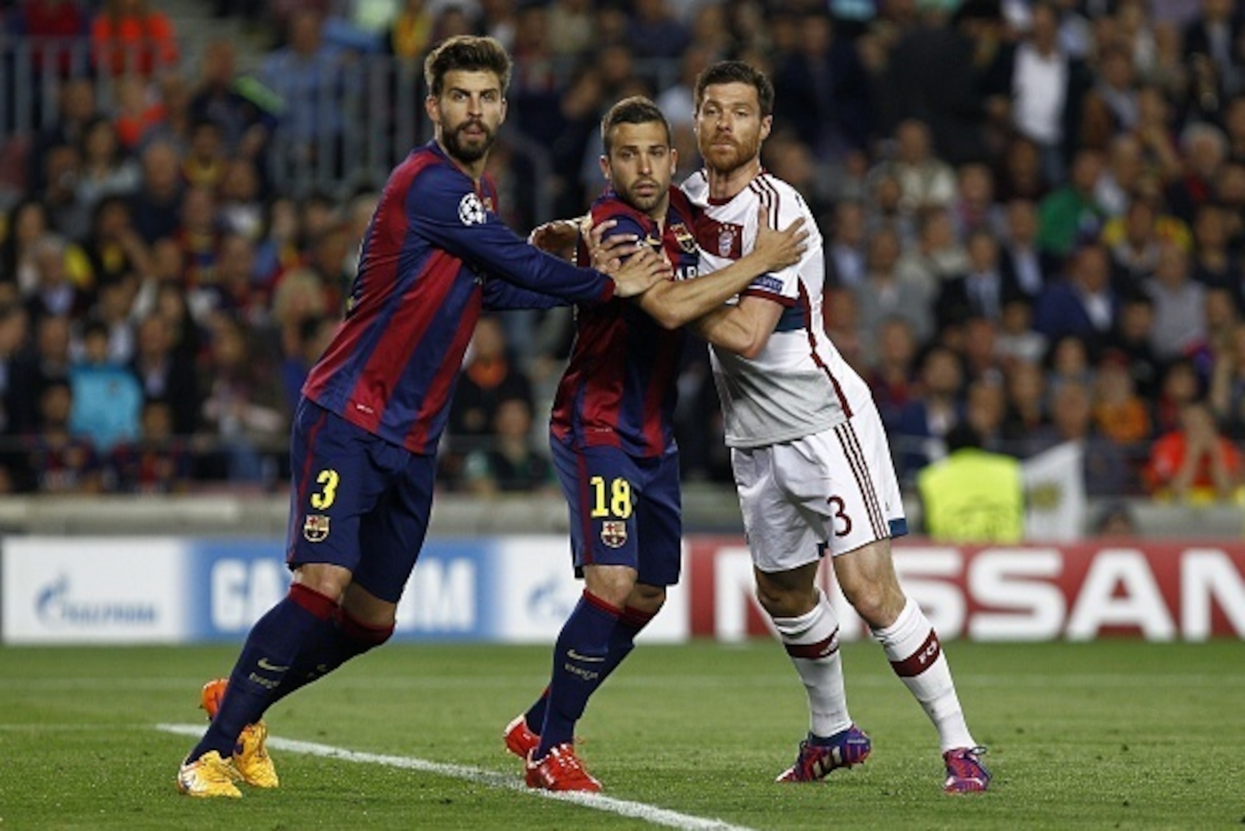 Bayern Munich's Spanish midfielder Xabi Alonso (R) pushes Barcelona's defender Jordi Alba (C) next to Barcelona's defender Gerard Pique (L) during the UEFA Champions League football match FC Barcelona vs FC Bayern Muenchen at the Camp Nou stadium in Barce