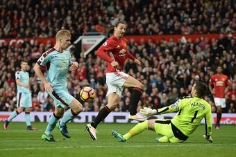 Burnley's English goalkeeper Tom Heaton (R) saves a shot from Manchester United's Swedish striker Zlatan Ibrahimovic (C) during the English Premier League football match between Manchester United and Burnley at Old Trafford in Manchester, north west Engla