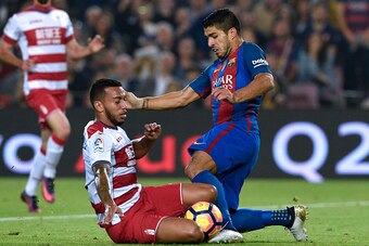 Barcelona's Uruguayan forward Luis Suarez (R) vies with Granada's Portuguese midfielder Ruben Vezo during the Spanish league football match between FC Barcelona and Granada FC at the Camp Nou stadium in Barcelona on October 29, 2016. / AFP / LLUIS GENE   
