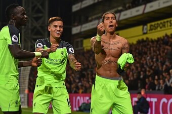 Liverpool's Brazilian midfielder Roberto Firmino (R) celebrates with Liverpool's Senegalese midfielder Sadio Mane (L) and Liverpool's Brazilian midfielder Philippe Coutinho after scoring their fourth goal during the English Premier League football match b