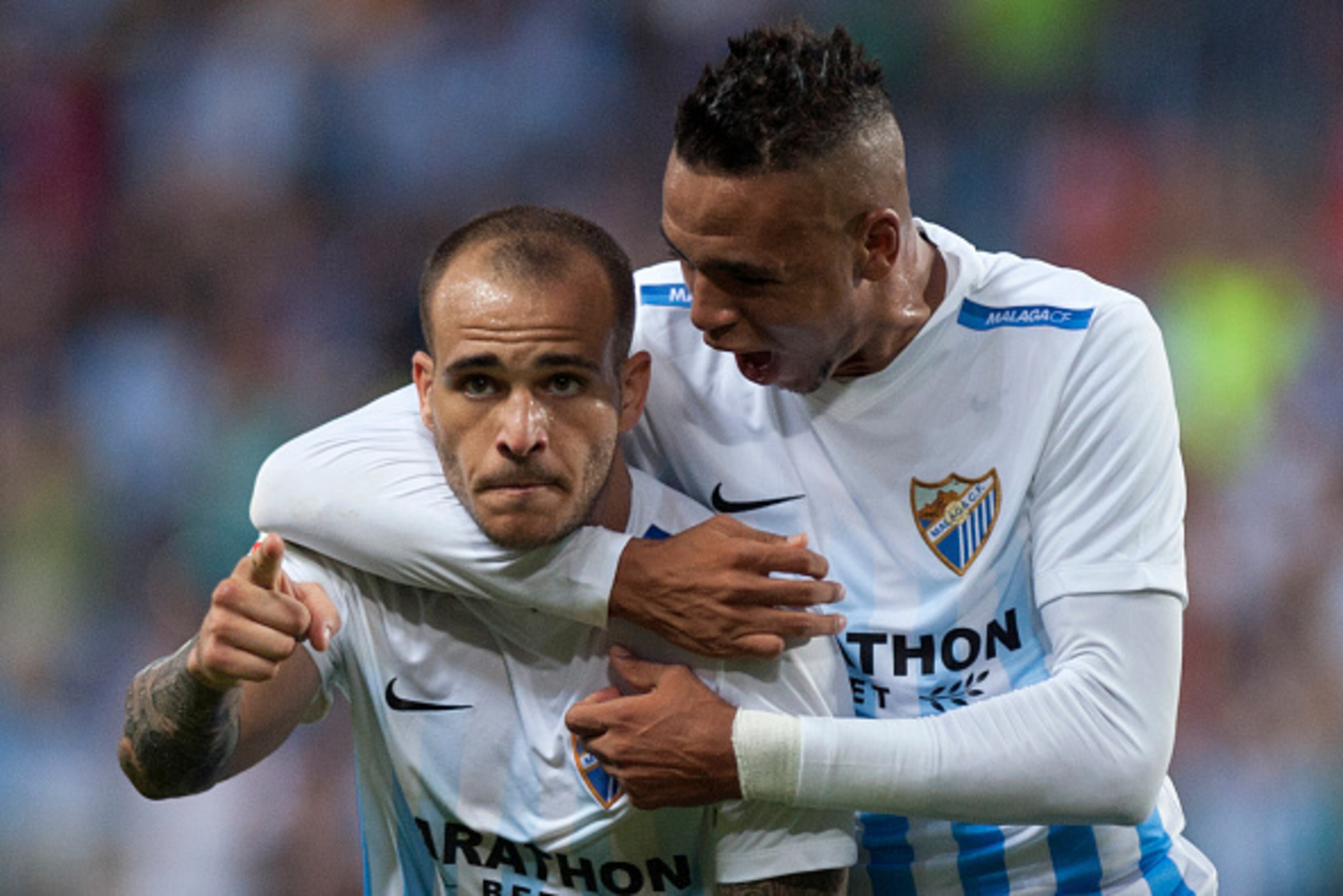 Malaga's forward Sandro Ramirez (L) celebrates with Malagas Morocco forward Youssef En-Nesyri after scoring during the Spanish league football match Malaga CF vs Athletic Club Bilbao at La Rosaleda stadium in Malaga on October 2, 2016. / AFP / JORGE GUERR