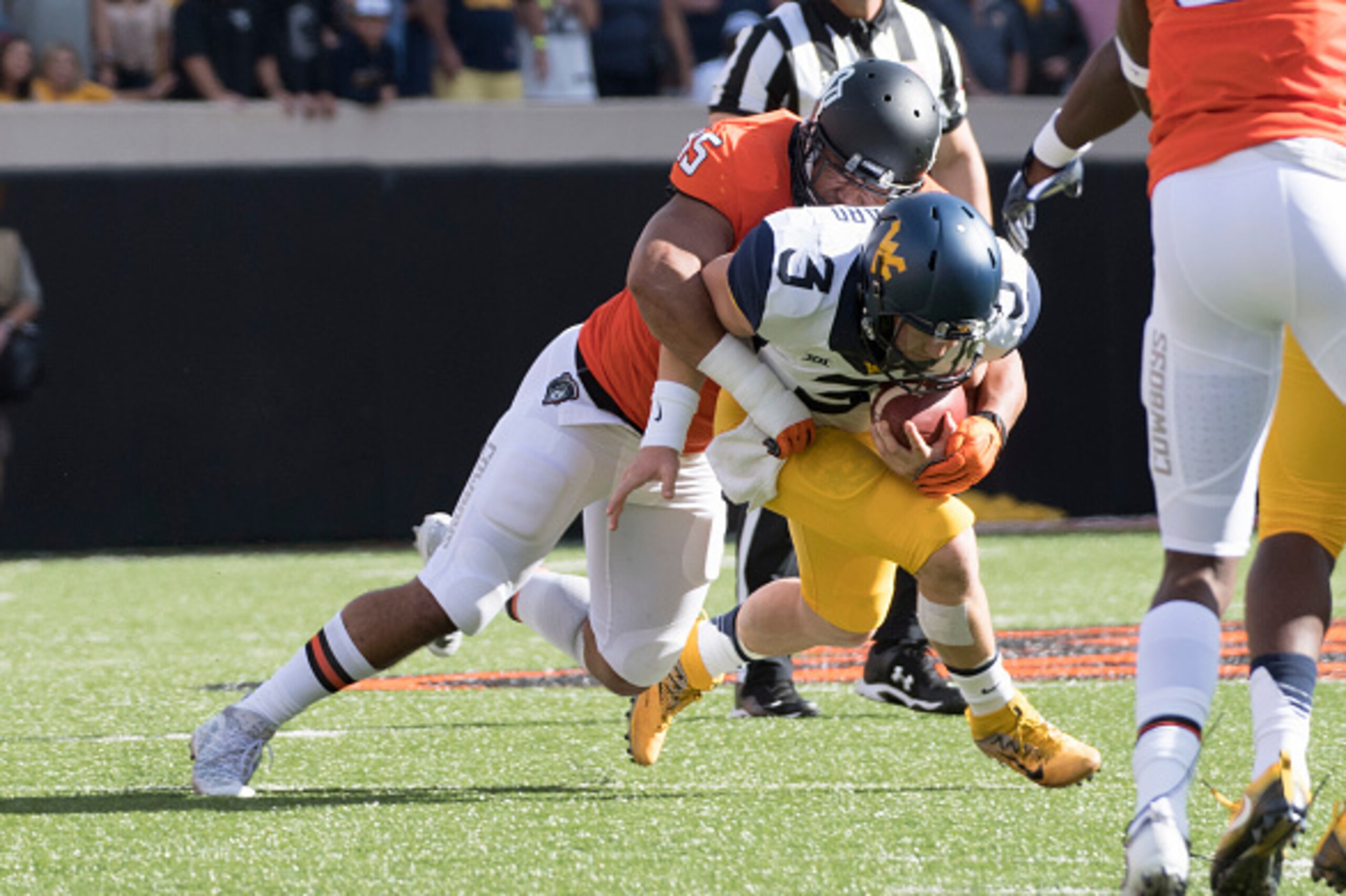 STILLWATER, OK - OCTOBER 29:  Linebacker Chad Whitener #45 of the Oklahoma State Cowboys sacks quarterback Skyler Howard #3 of the West Virginia Mountaineers during the first half of a NCAA football game at Boone Pickens Stadium October 29, 2016 in Stillw