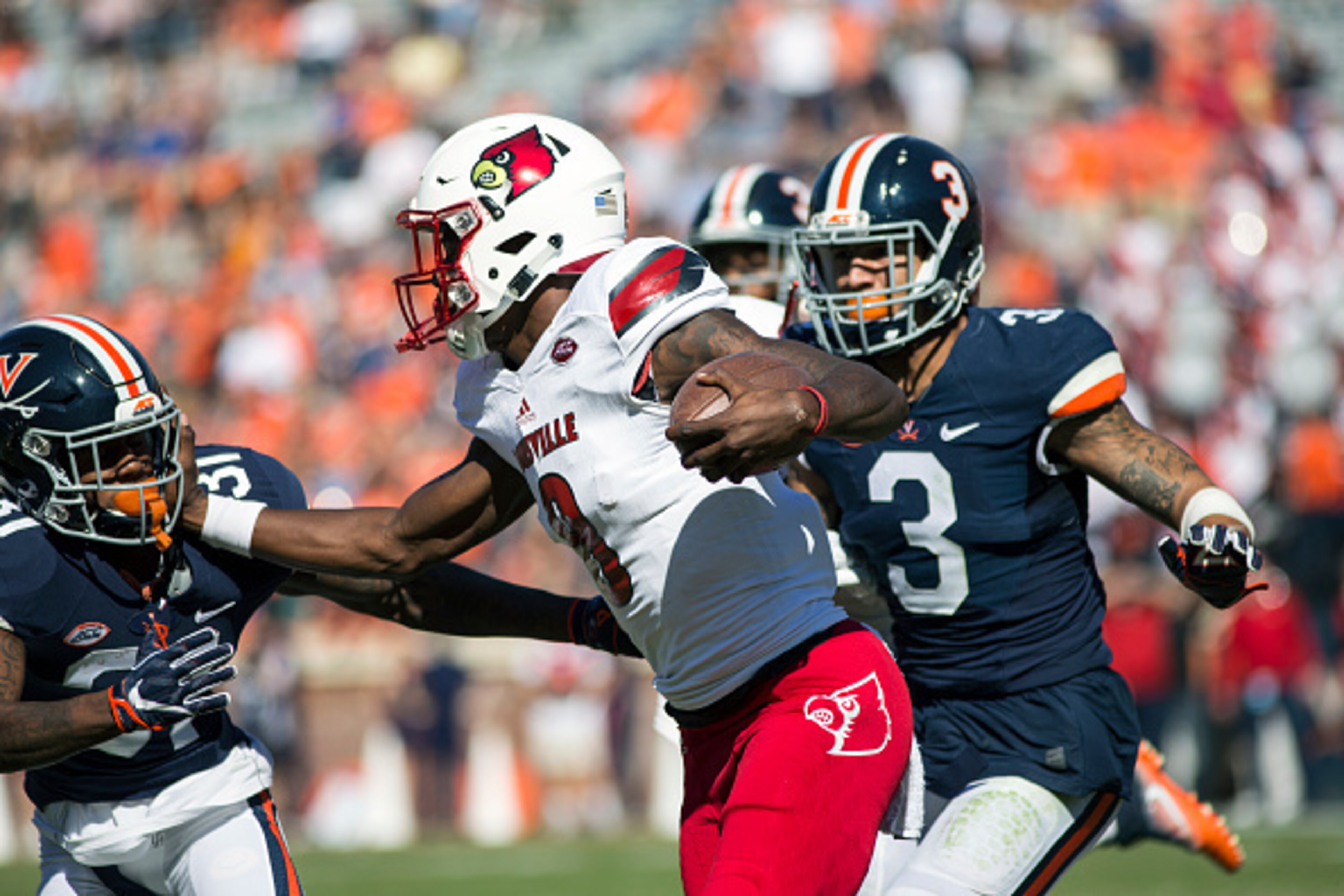 CHARLOTTESVILLE, VA - OCTOBER 29: Lamar Jackson #8 of the Louisville Cardinals pushes past Kareem Gibson #31 of the Virginia Cavaliers during their game at Scott Stadium on October 29, 2016 in Charlottesville, Virginia. (Photo by Chet Strange/Getty Images CHARLOTTESVILLE, VA - OCTOBER 29: Lamar Jackson #8 of the Louisville Cardinals pushes past Kareem Gibson #31 of the Virginia Cavaliers during their game at Scott Stadium on October 29, 2016 in Charlottesville, Virginia. (Photo by Chet Strange/Getty Images