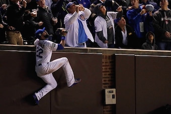 CHICAGO, IL - OCTOBER 30:  Jason Heyward #22 of the Chicago Cubs climbs the wall to catch a foul ball in the third inning against the Cleveland Indians in Game Five of the 2016 World Series at Wrigley Field on October 30, 2016 in Chicago, Illinois.  (Phot
