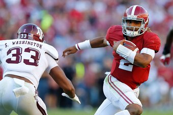 TUSCALOOSA, AL - OCTOBER 22:  Jalen Hurts #2 of the Alabama Crimson Tide rushes away from Shaan Washington #33 of the Texas A&M Aggies at Bryant-Denny Stadium on October 22, 2016 in Tuscaloosa, Alabama.  (Photo by Kevin C. Cox/Getty Images)