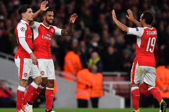 Arsenal's English midfielder Theo Walcott (C) celebrates scoring his team's second goal with Arsenal's Spanish defender Hector Bellerin (L) and Arsenal's Spanish midfielder Santi Cazorla during the UEFA Champions League Group A football match between Arse