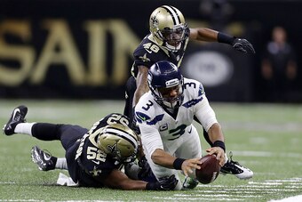 NEW ORLEANS, LA - OCTOBER 30: Russell Wilson #3 of the Seattle Seahawks dives for a first down as Craig Robertson #52 of the New Orleans Saints and Vonn Bell #48 defend during the second half of a game at the Mercedes-Benz Superdome on October 30, 2016 in