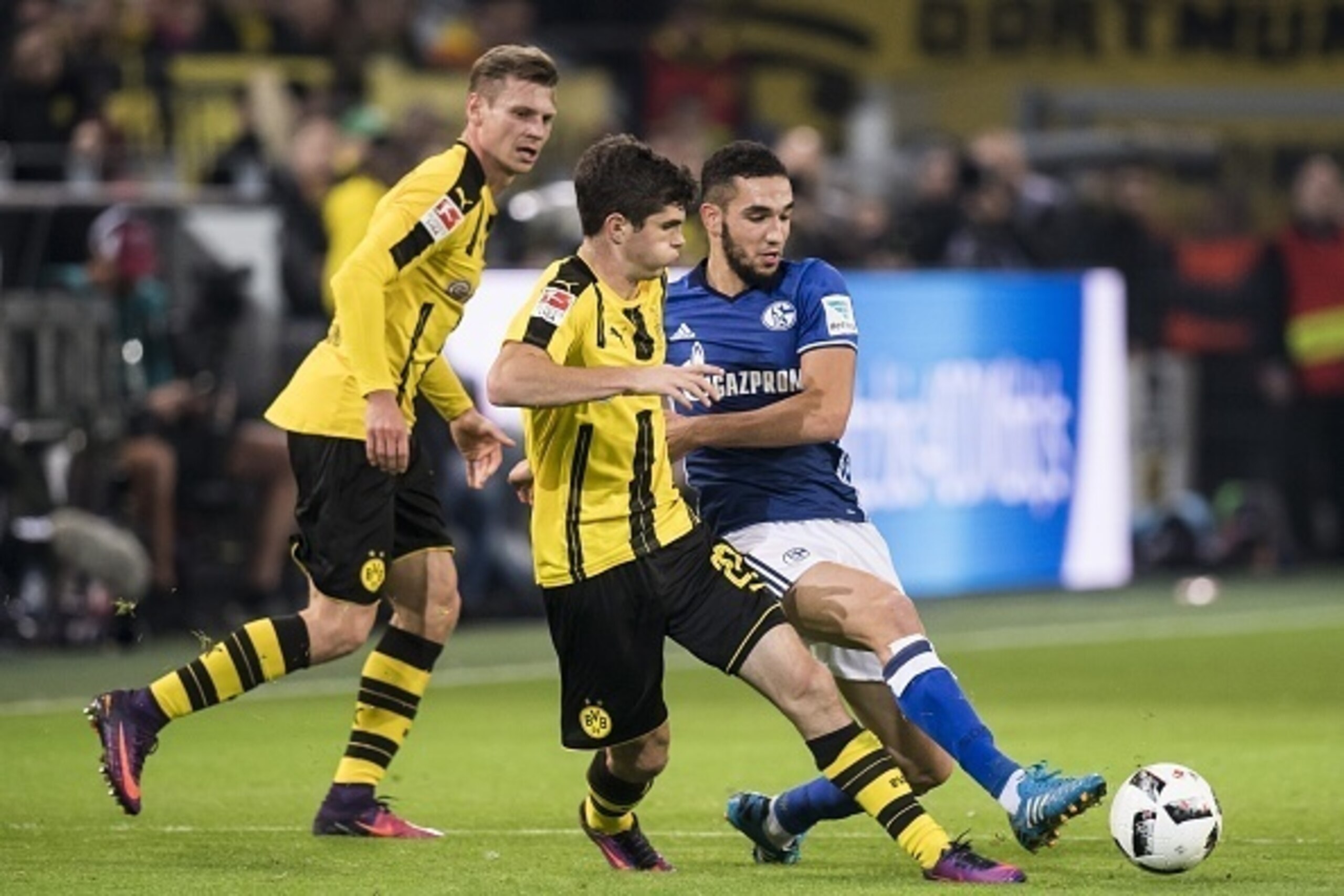 (L-R) Lukasz Piszczek of Borussia Dortmund, Christian Pulisic of Borussia Dortmund, Nabil Bentalab of Schalke 04during the Bundesliga match between Borussia Dortmund and Schalke 04 on October 29, 2016 at the Signal Iduna Park stadium in Dortmund, Germany.