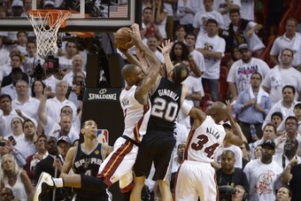 Chris Bosh (L) of the Miami Heat snares a rebound before teammate Ray Allen (R) against Manu Ginobili  (C) of the San Antonio Spurs during overtime in Game 6 of the NBA Finals against the Miami Heat at the American Airlines Arena June 19, 2013 in Miami, F