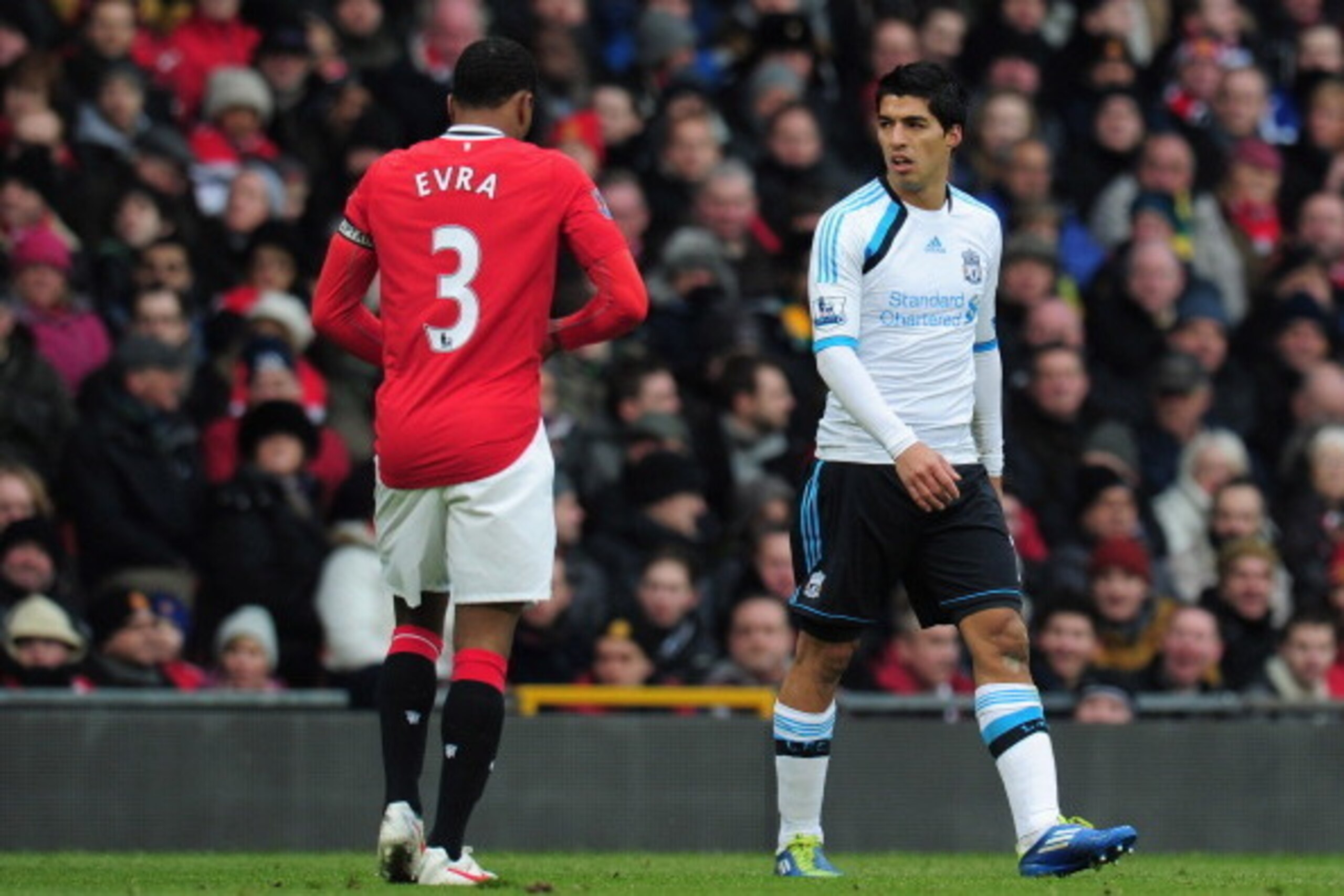 MANCHESTER, ENGLAND - FEBRUARY 11:  Luis Suarez of Liverpool looks at Patrice Evra of Manchester United during the Barclays Premier League match between Manchester United and Liverpool at Old Trafford on February 11, 2012 in Manchester, England.  (Photo b