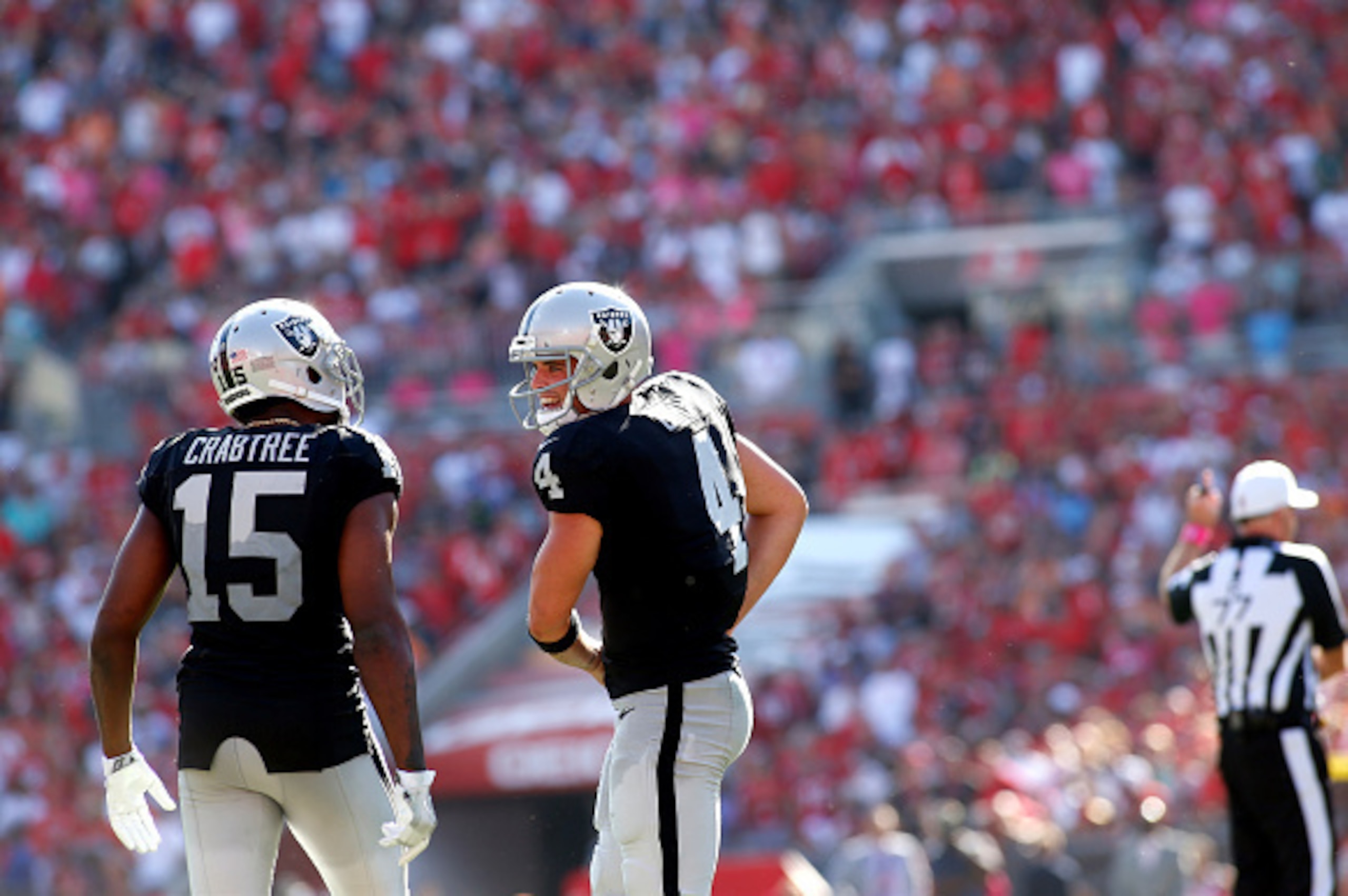 TAMPA, FL - OCTOBER 30:  Quarterback Derek Carr #4 of the Oakland Raiders talks to wide receiver Michael Crabtree #15 on the field during the fourth quarter of an NFL game on October 30, 2016 at Raymond James Stadium in Tampa, Florida. (Photo by Brian Bla