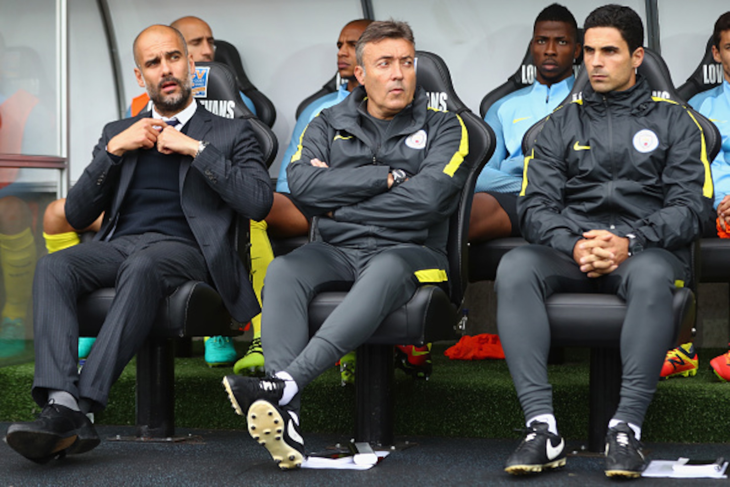SWANSEA, WALES - SEPTEMBER 24: Josep Guardiola (L) the manager of Manchester City sits alongside assistant coaches Domenec Torrent (C) and Mikel Arteta (R) during the Premier League match between Swansea City and Manchester City at Liberty Stadium on Sept