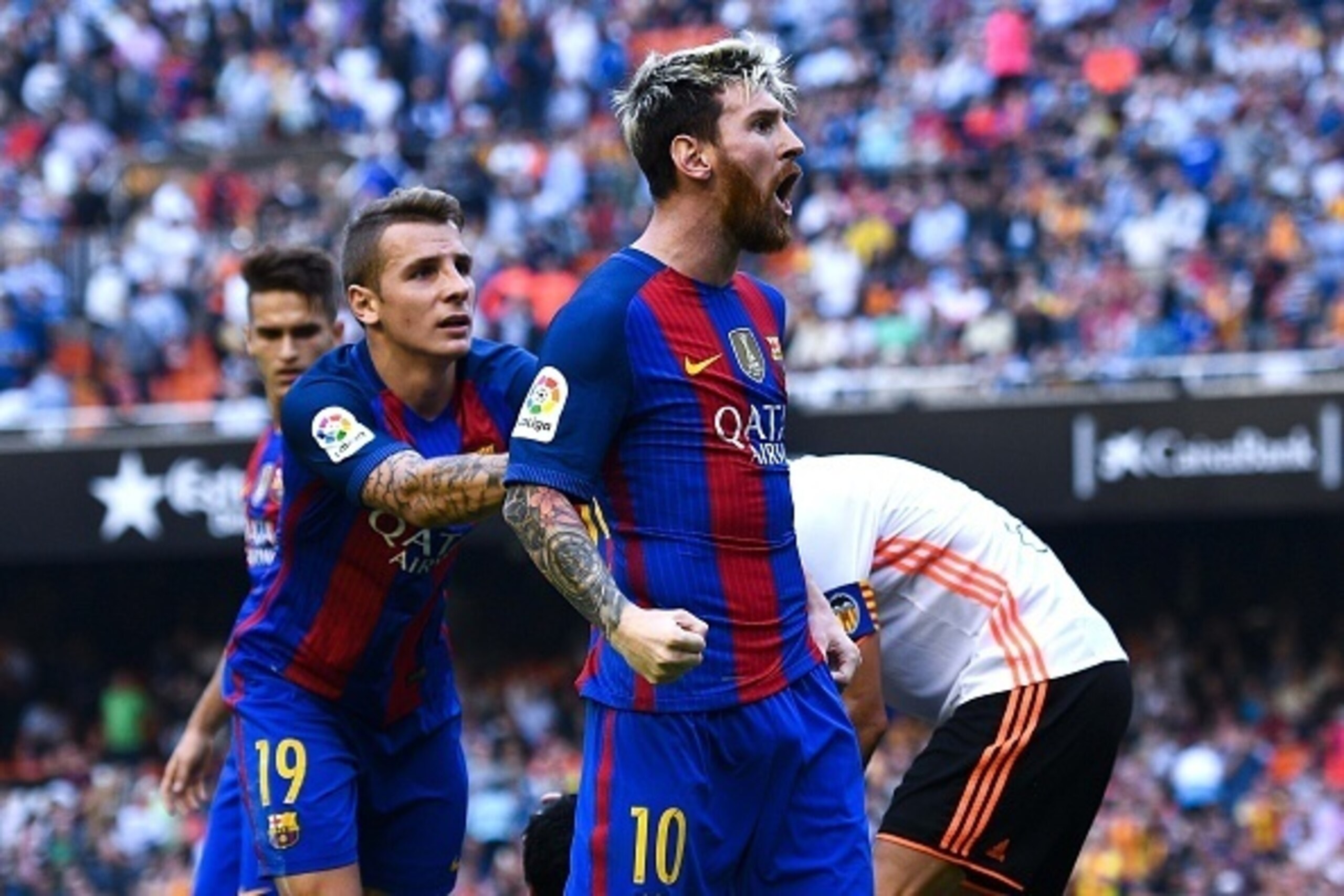 VALENCIA, SPAIN - OCTOBER 22:  Lionel Messi of FC Barcelona celebrates with his team mates as Neymar Jr. and Luis Suarez reacts on the pitch after being hit by objects thrown from the seats after scoring his team's third from the penalty spot during the L