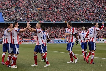Atletico Madrid's midfielder Saul Niguez (2ndL) celebrates with teammates fater scoring their second goal during the Spanish league football match Club Atletico de Madrid vs Real Madrid CF at the Vicente Calderon stadium in Madrid on February 7, 2015.   A