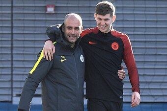 Manchester City's Spanish manager Pep Guardiola (L) hugs England's defender John Stones (R) during a team training session at Manchester City Football Academy Campus in Manchester, north west England, on October 18, 2016 ahead of their UEFA Champions Leag
