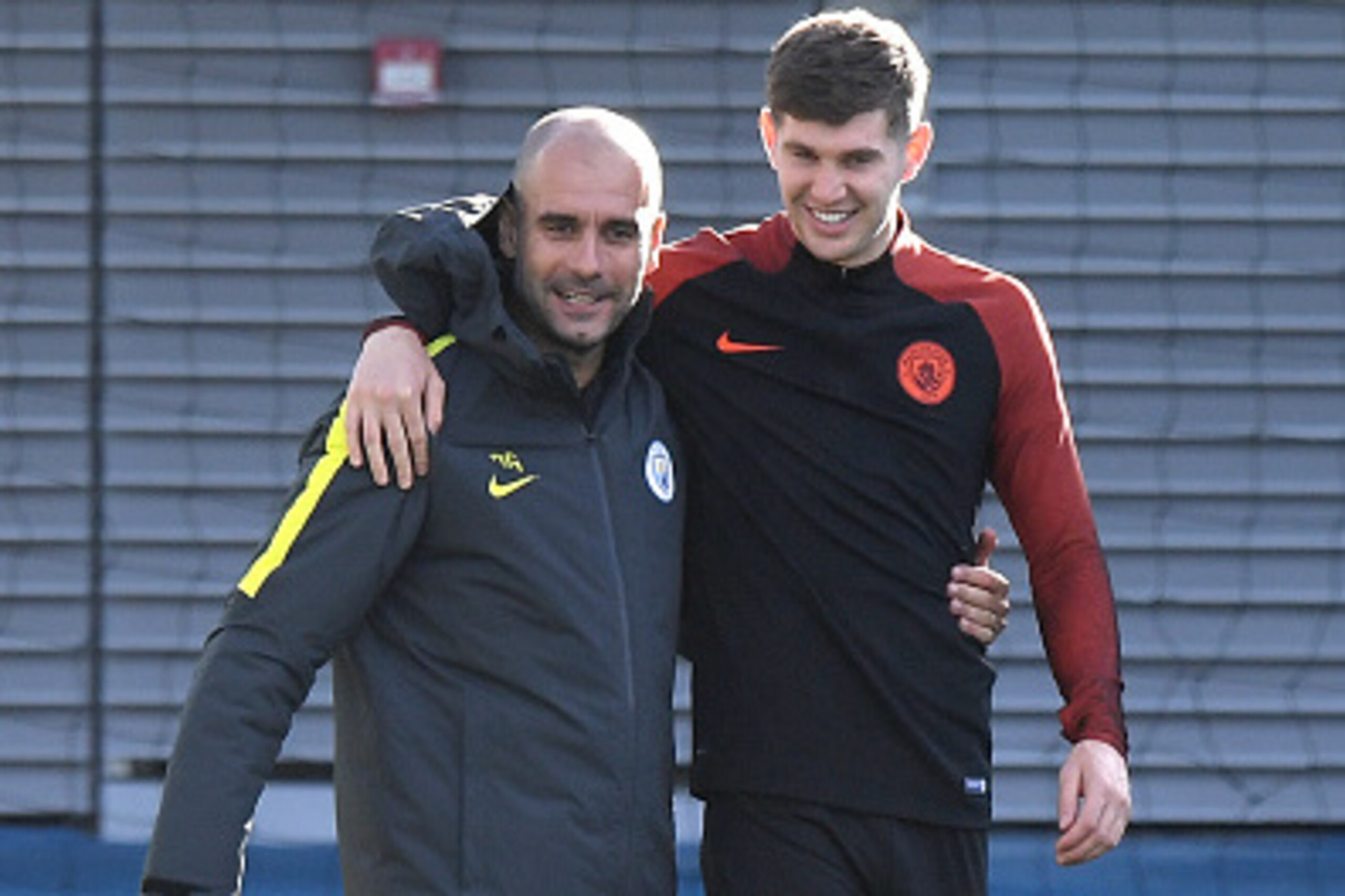 Manchester City's Spanish manager Pep Guardiola (L) hugs England's defender John Stones (R) during a team training session at Manchester City Football Academy Campus in Manchester, north west England, on October 18, 2016 ahead of their UEFA Champions Leag