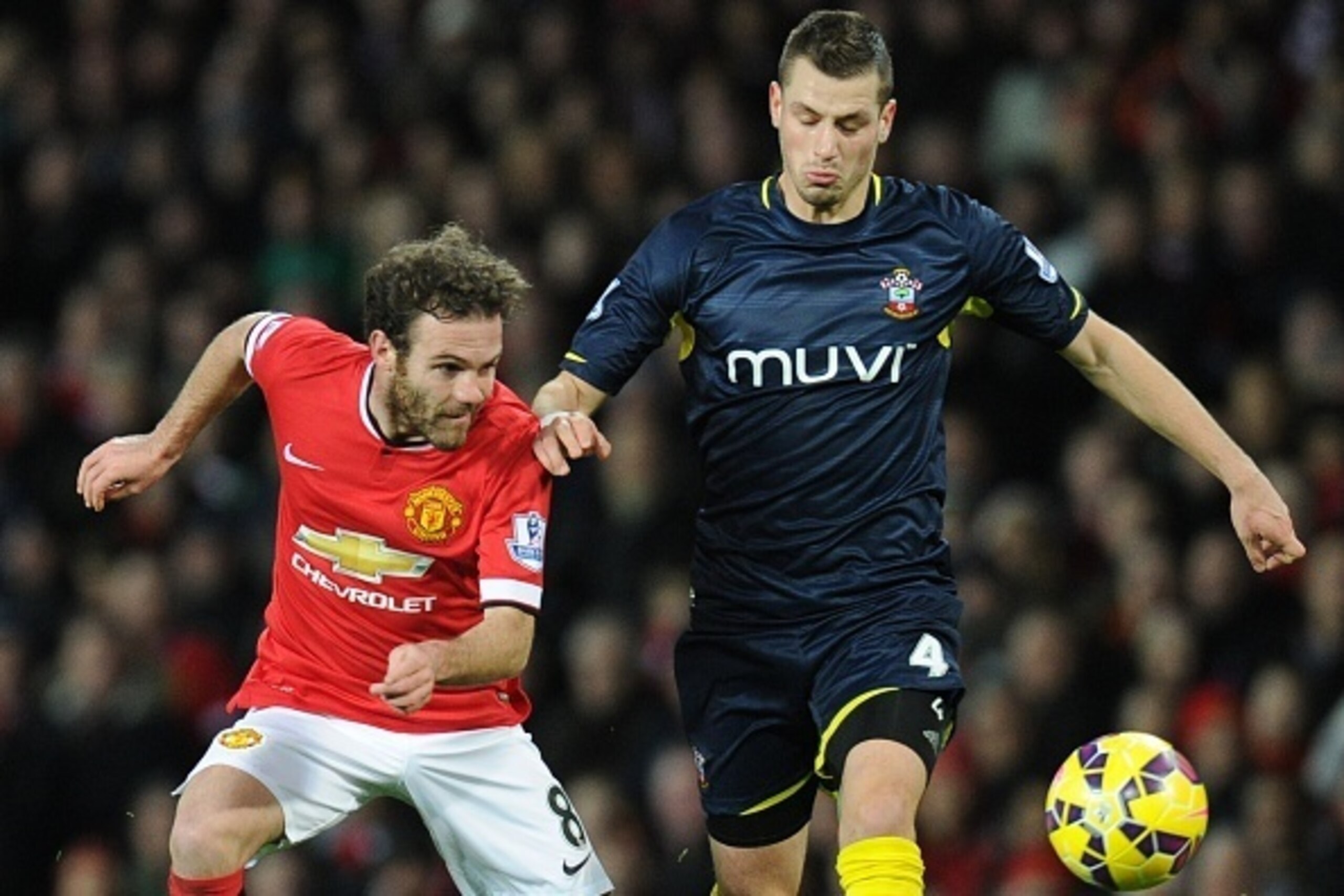 Manchester United's Spanish midfielder Juan Mata (L) pressures Southampton's French midfielder Morgan Schneiderlin (R) during the English Premier League football match between Manchester United and Southampton at Old Trafford in Manchester, North West Eng