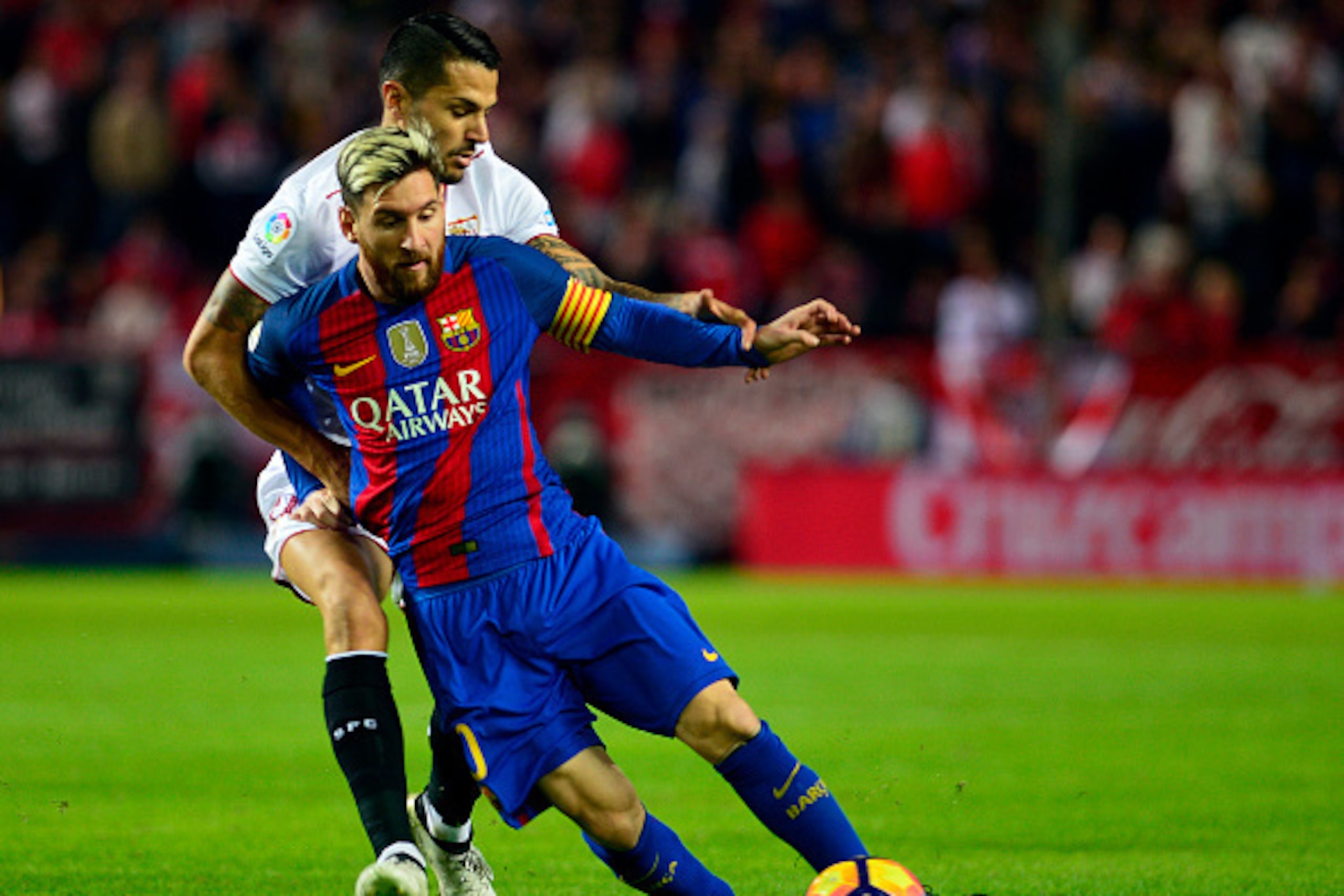 Barcelona's Argentinian forward Lionel Messi (R) vies with Sevilla's midfielder Vitoloduring the Spanish league football match Sevilla FC vs FC Barcelona at the Ramon Sanchez Pizjuan stadium in Sevilla on November 6, 2016. / AFP / CRISTINA QUICLER        