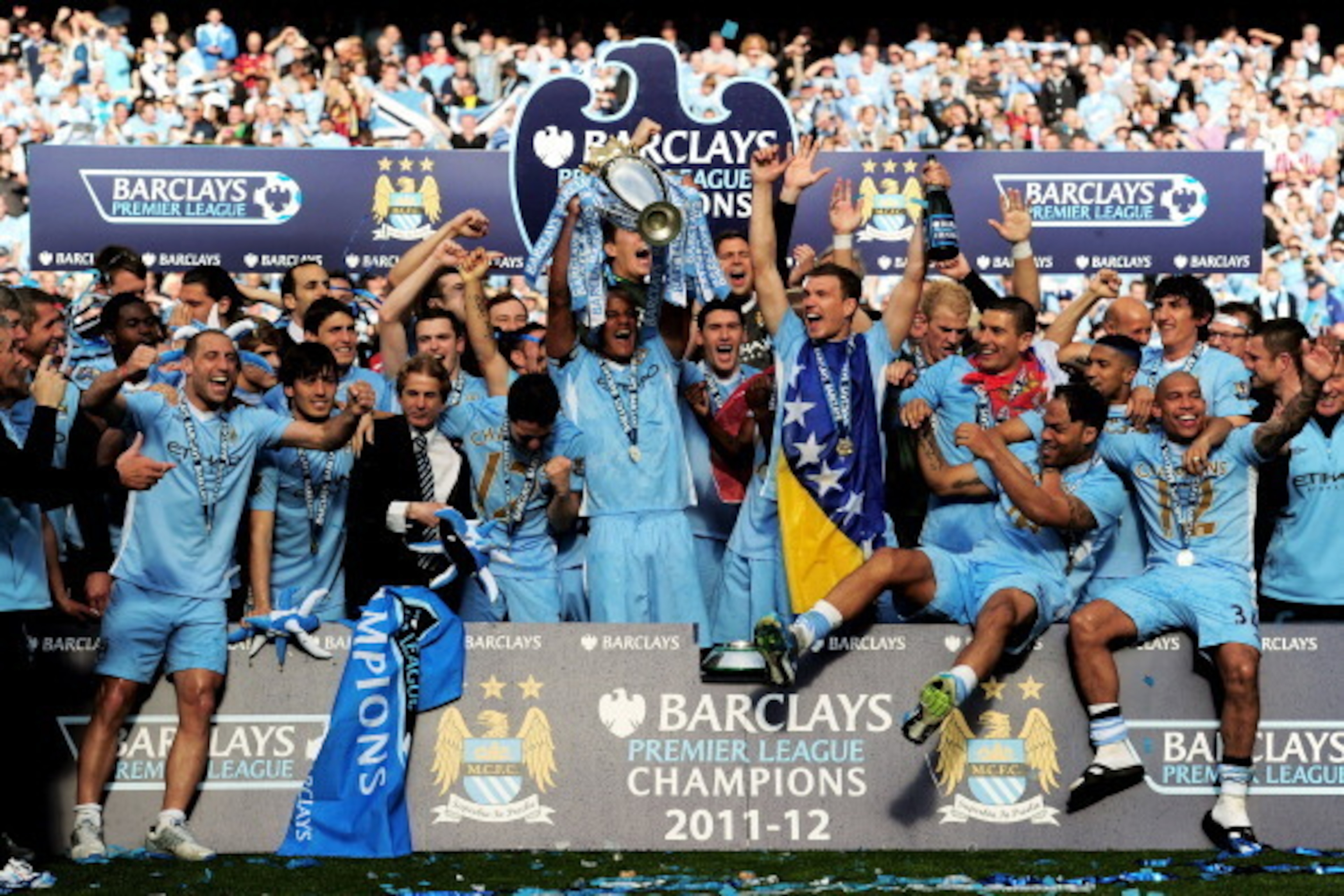 MANCHESTER, ENGLAND - MAY 13:  The Manchester City players celebrate with the trophy following the Barclays Premier League match between Manchester City and Queens Park Rangers at the Etihad Stadium on May 13, 2012 in Manchester, England.  (Photo by Shaun