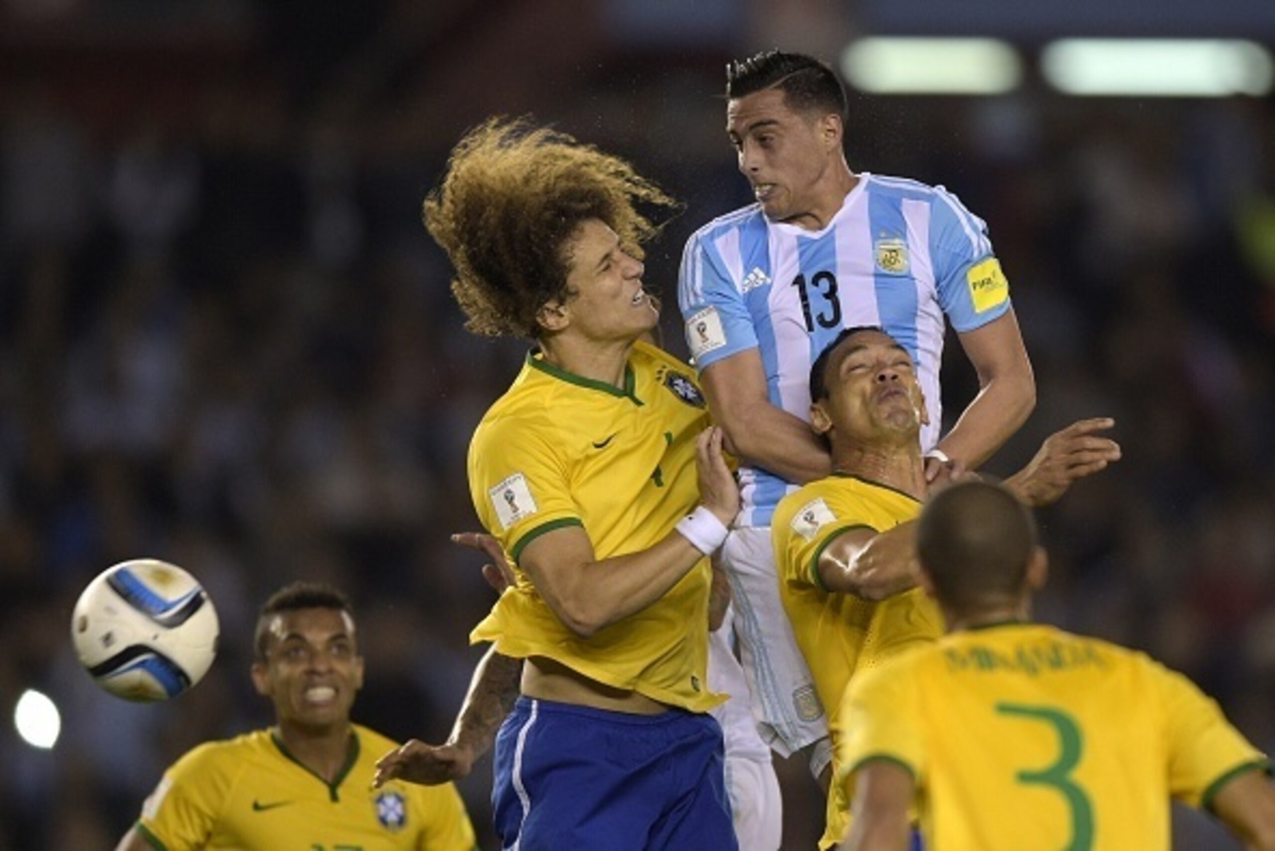 Brazil's David Luiz (L) and Argentina's Ramiro Funes (R-top) try to head the ball during their Russia 2018 FIFA World Cup South American Qualifiers football match, in Buenos Aires, on November 13, 2015.  AFP PHOTO / JUAN MABROMATA        (Photo credit sho