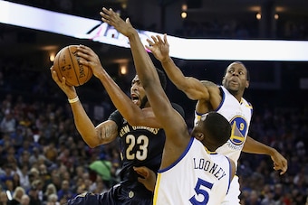 OAKLAND, CA - NOVEMBER 07:  Anthony Davis #23 of the New Orleans Pelicans goes up for a shot against Kevon Looney #5 and Andre Iguodala #9 of the Golden State Warriors at ORACLE Arena on November 7, 2016 in Oakland, California. NOTE TO USER: User expressl