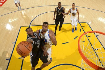 OAKLAND, CA - OCTOBER 25:  Jonathon Simmons #17 of the San Antonio Spurs drives to the basket against Kevon Looney #5 of the Golden State Warriors on October 25, 2016 at ORACLE Arena in Oakland, California. NOTE TO USER: User expressly acknowledges and ag