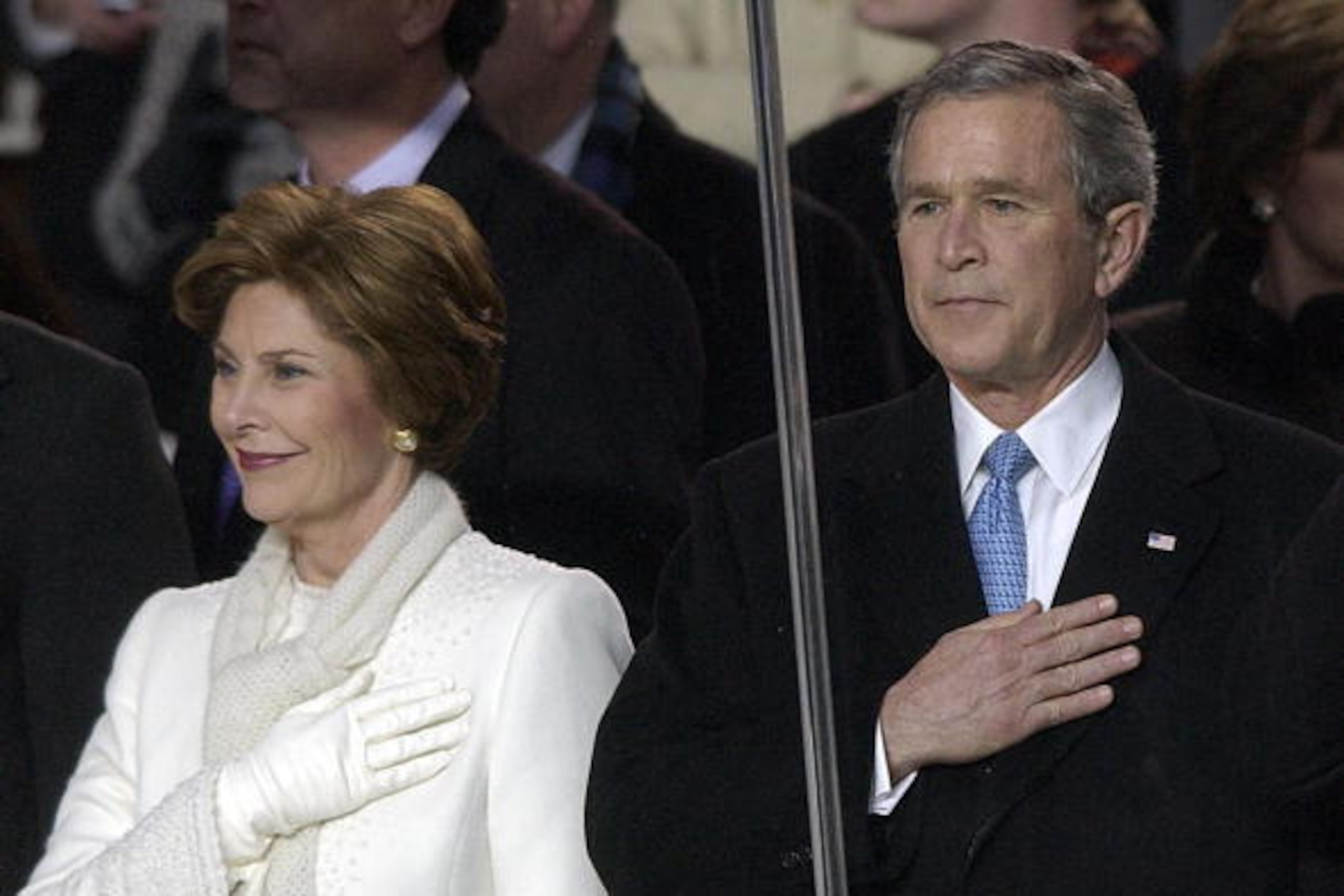 WASHINGTON, UNITED STATES:  US President George W. Bush and First Lady Laura listen to the national anthem from inside the presidential viewing stand overlooking Pennsylania Avenue during the Inaugural Parade 20 January 2005 in Washington, DC. Bush launch