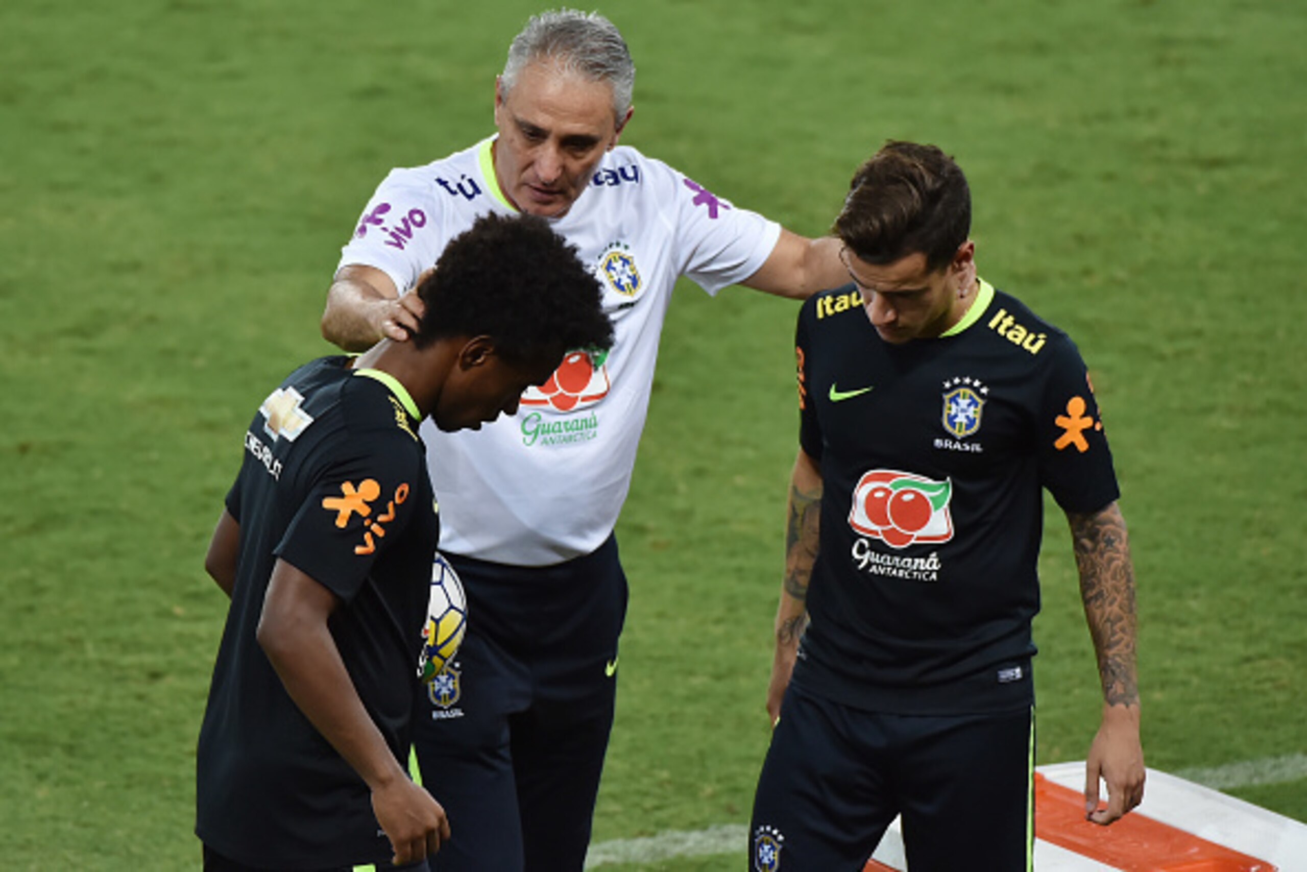 Brazil's team coach Tite (C) speaks with players Willian (L) and Philippe Coutinho (R) after a training session at the Arena Dunas stadium in Natal, Brazil on October 4, 2016. 
Brazil will face Bolivia in a FIFA World Cup Russia 2018 qualifier match on Oc