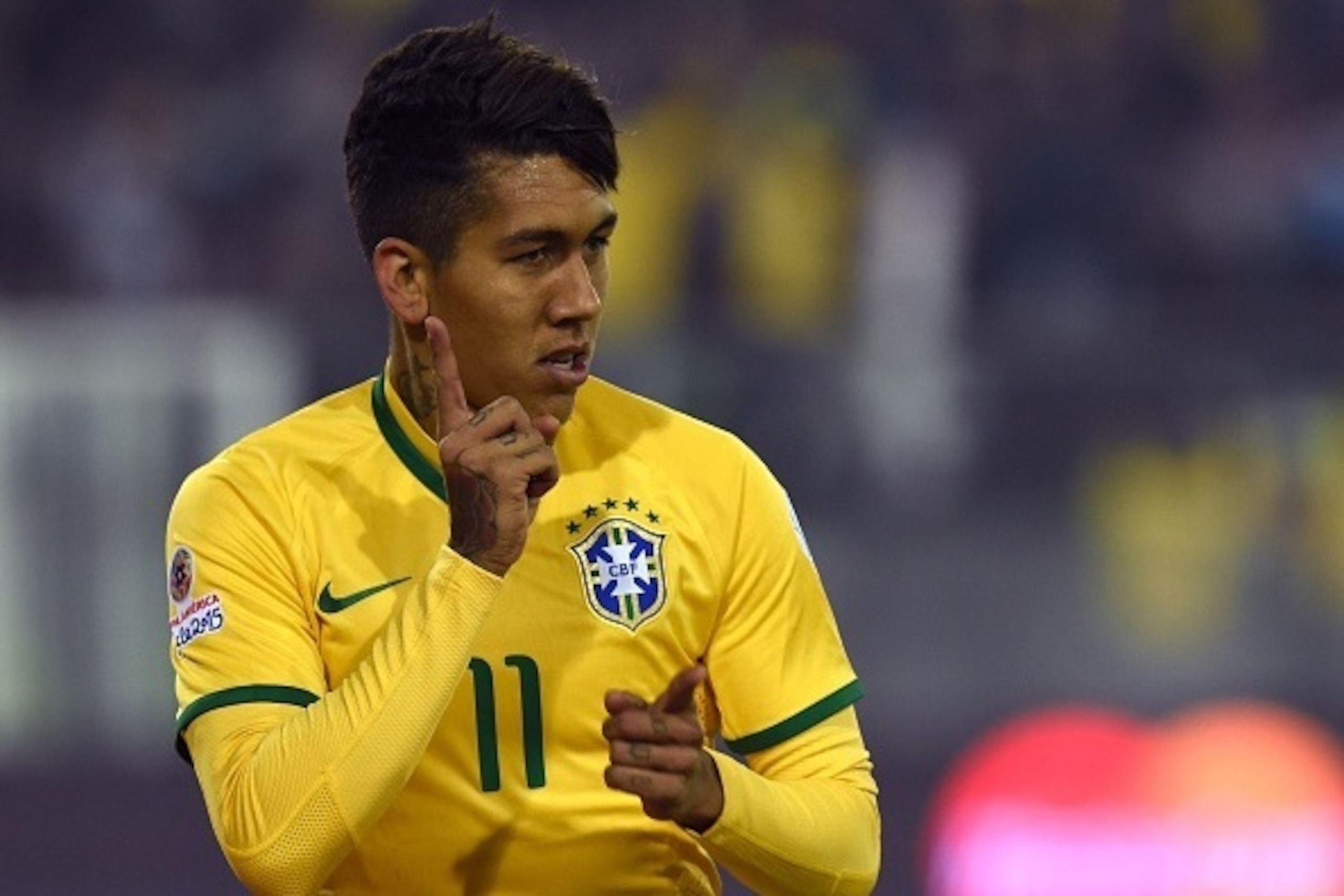 Brazil's forward Roberto Firmino celebrates after scoring the team's second goal against Venezuela during their 2015 Copa America football championship match, at the Estadio Monumental David Arellano in Santiago, on June 21, 2015.    AFP PHOTO / PABLO POR