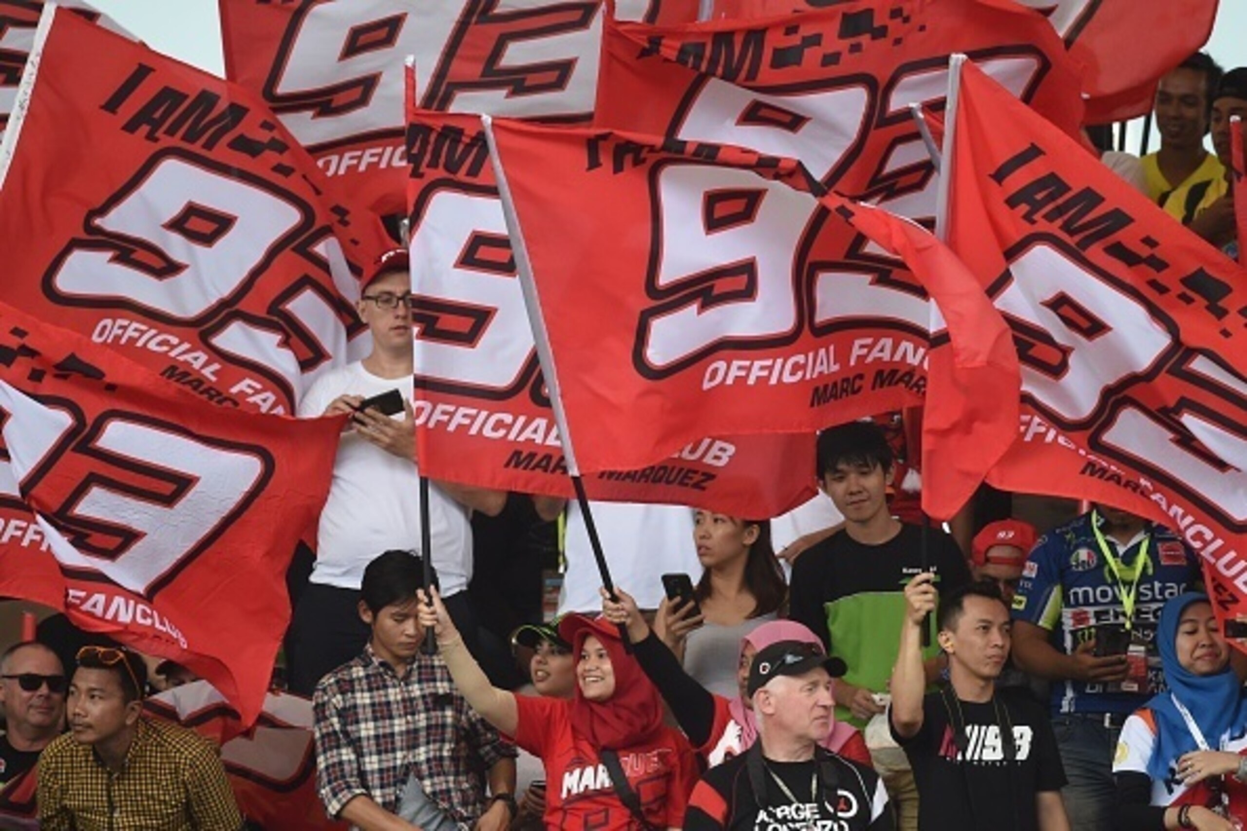 Supporters of Repsol Honda Team's Spanish rider Marc Marquez wave flags before the start of the Malaysian MotoGP race at the Sepang International circuit on October 30, 2016. / AFP / MOHD RASFAN        (Photo credit should read MOHD RASFAN/AFP/Getty Image