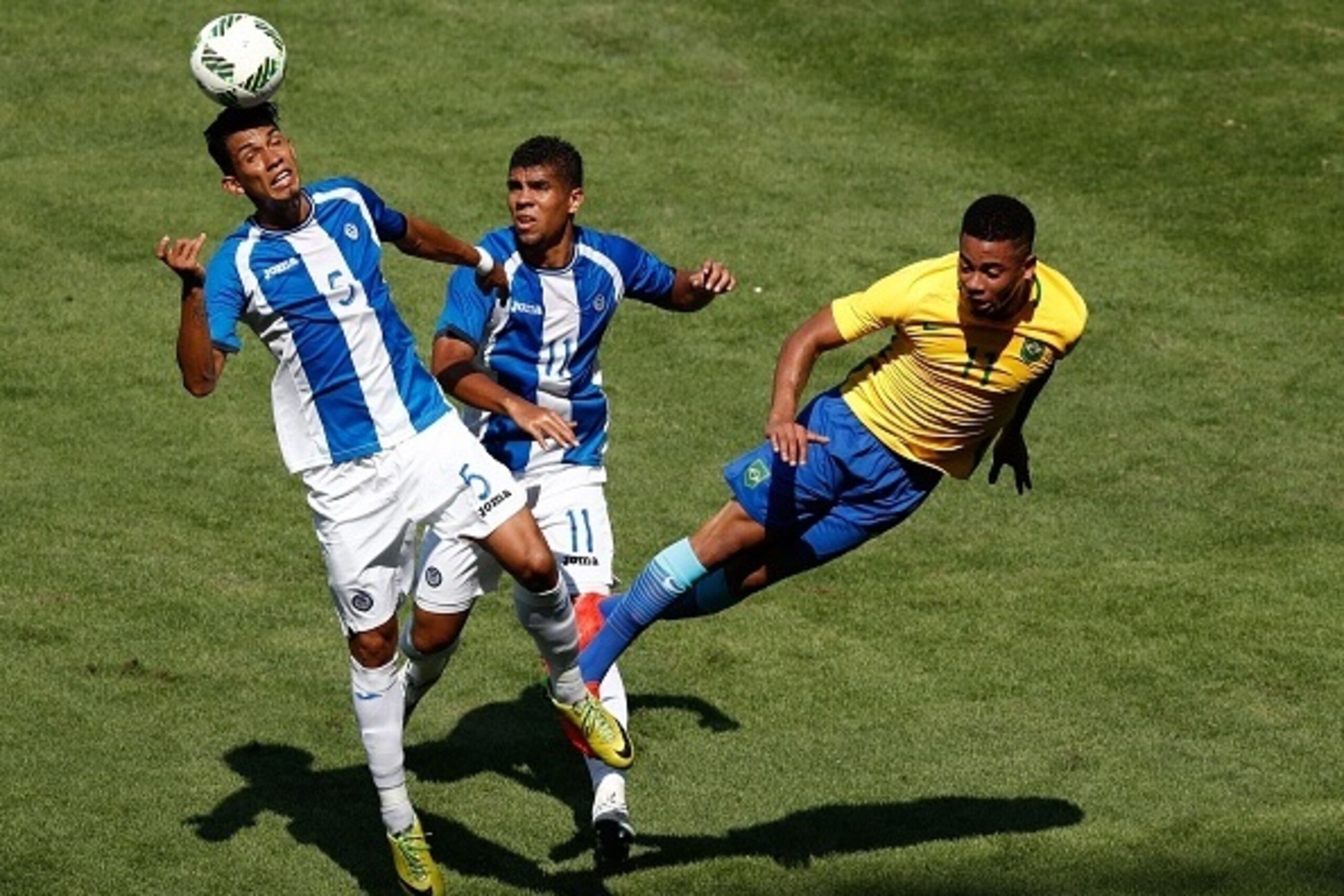 Honduras' Allans Vargas (L) heads the ball next to Honduras' Marcelo Espinal (C) and Brazil's Gabriel Jesus during their Rio 2016 Olympic Games men's football semifinal match at the Maracana stadium in Rio de Janeiro, Brazil, on August 17, 2016. / AFP / O