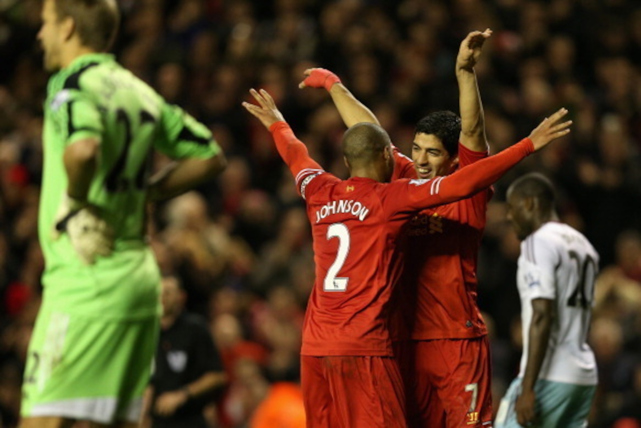 LIVERPOOL, ENGLAND - DECEMBER 07:  Luis Suarez of Liverpool celebrates scoring his team's third goal with team-mate Glen Johnson during the Barclays Premier League match between Liverpool and West Ham United at Anfield on December 7, 2013 in Liverpool, En