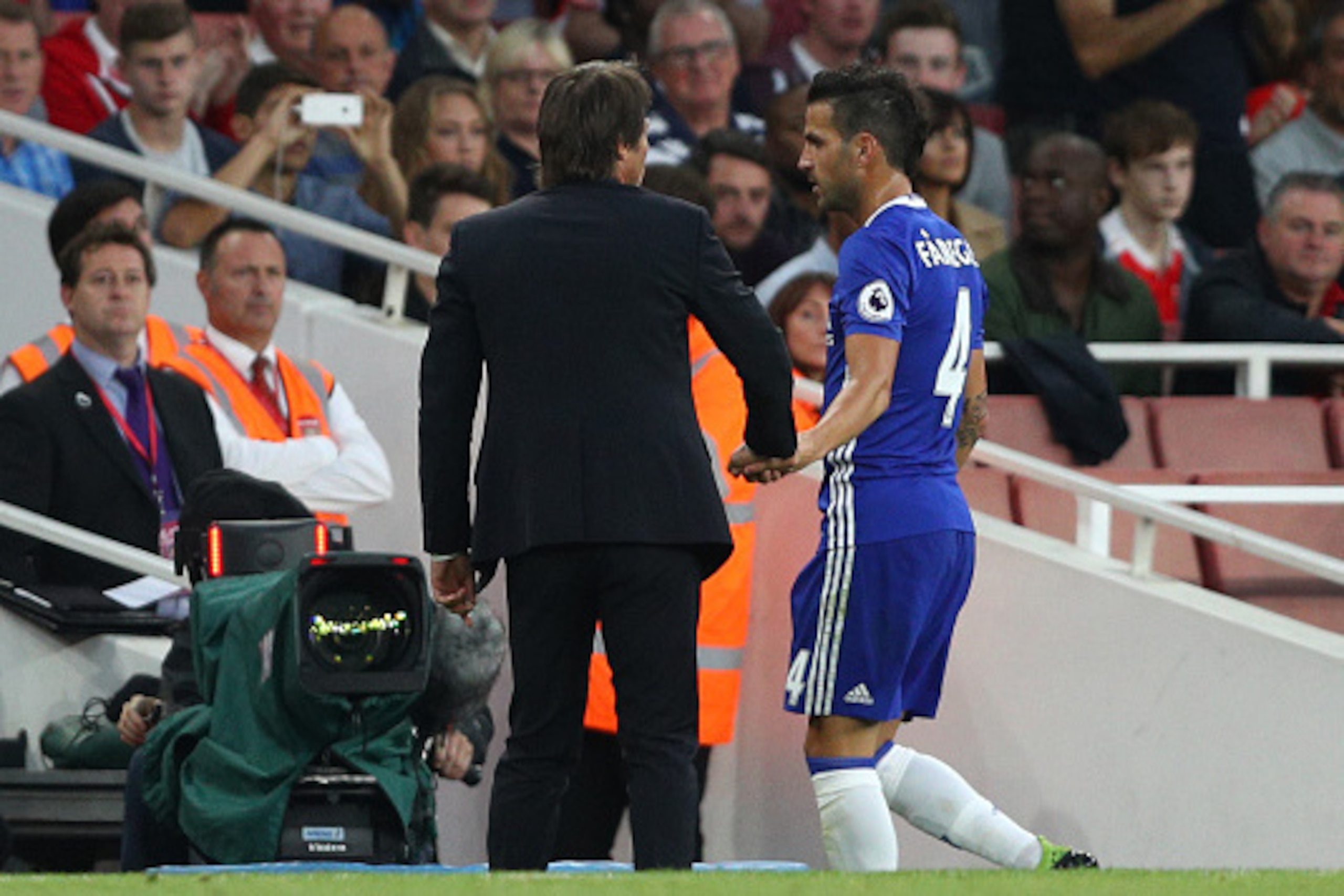 LONDON, ENGLAND - SEPTEMBER 24: Cesc Fabregas of Chelsea (R) speaks to Antonio Conte, Manager of Chelsea (L) after being subbed during the Premier League match between Arsenal and Chelsea at the Emirates Stadium on September 24, 2016 in London, England.  