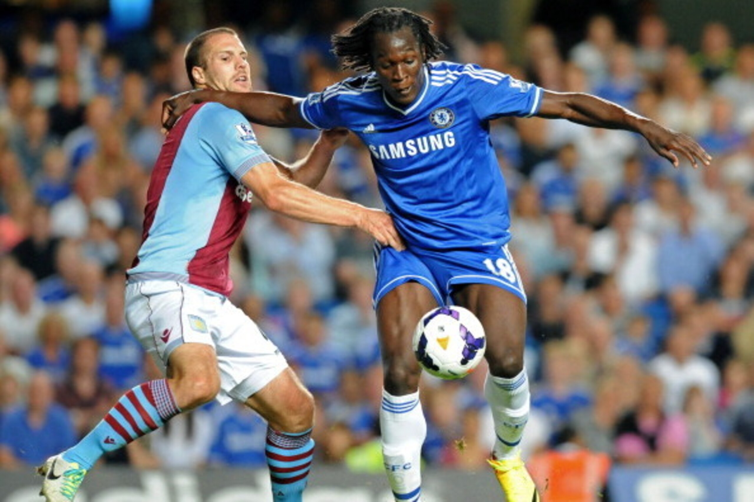 Chelsea's Belgian striker Romelu Lukaku (R) vies with Aston Villa's Dutch defender Ron Vlaar (L) during the English Premier League football match between Chelsea and Aston Villa at Stamford Bridge in London on August 21, 2013. Chelsea won the game 2-1. AF