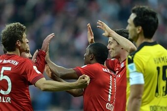 (L-R) Bayern Munich's striker Thomas Mueller, Bayern Munich's midfielder Mario Goetze, FC Bayern Munich's Brazilian midfielder Douglas Costa and FC Bayern Munich's Polish striker Robert Lewandowski celebrate after the third goal for Munich beside of Dortm
