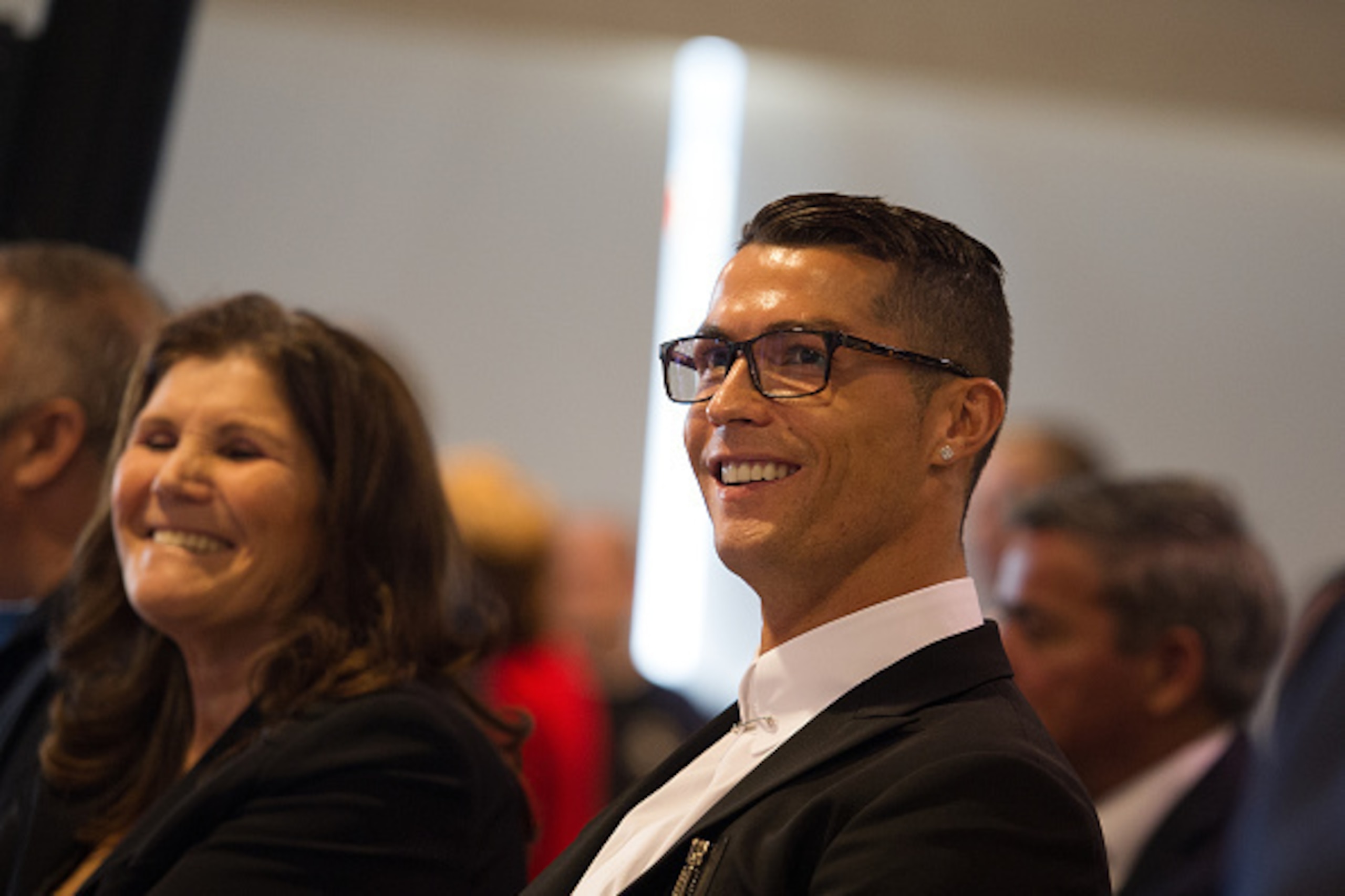 MADRID, SPAIN - NOVEMBER 07:  Cristiano Ronaldo of Real Madrid smiles with his mother Maria Dolores dos Santos Aveiro while they watch highlights of his favourite goals on a video display screen before holding his press conference after signing a new five