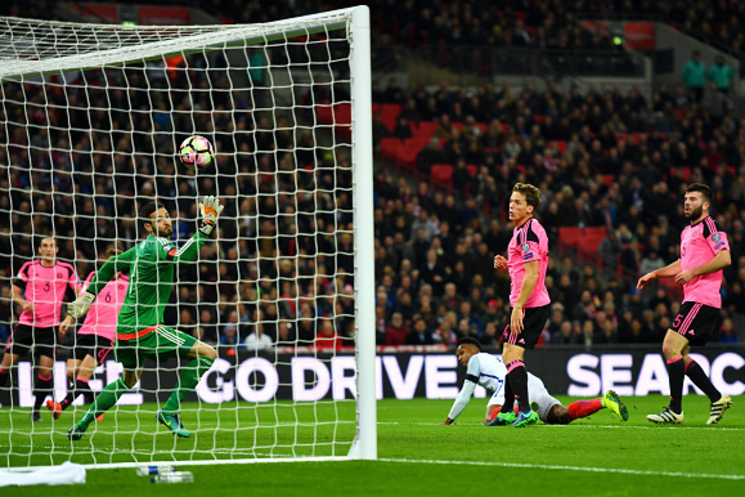 LONDON, ENGLAND - NOVEMBER 11:  Daniel Sturridge of England (3R) beats goalkeeper Craig Gordon of Scotland to score their first goal during the FIFA 2018 World Cup qualifying match between England and Scotland at Wembley Stadium on November 11, 2016 in Lo