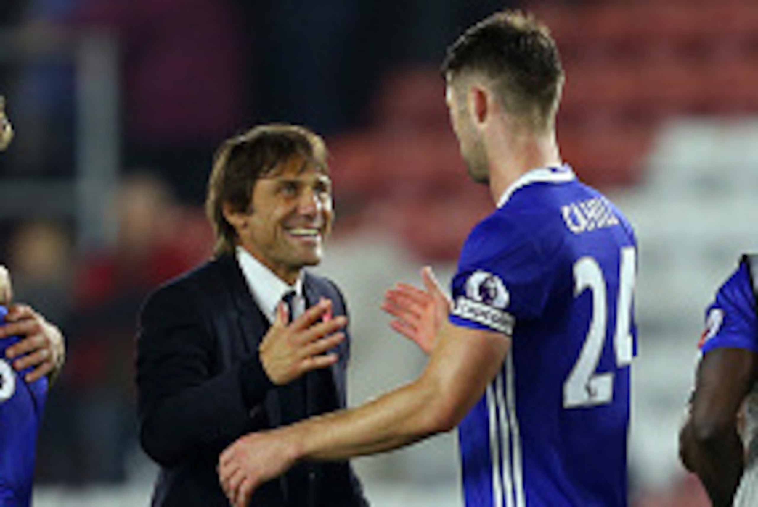 SOUTHAMPTON, ENGLAND - OCTOBER 30: A smiling Antonio Conte manager / head coach of Chelsea greets captain Gary Cahill of Chelsea as the rest of the team congratulate each other around him  the Premier League match between Southampton and Chelsea at St Mar