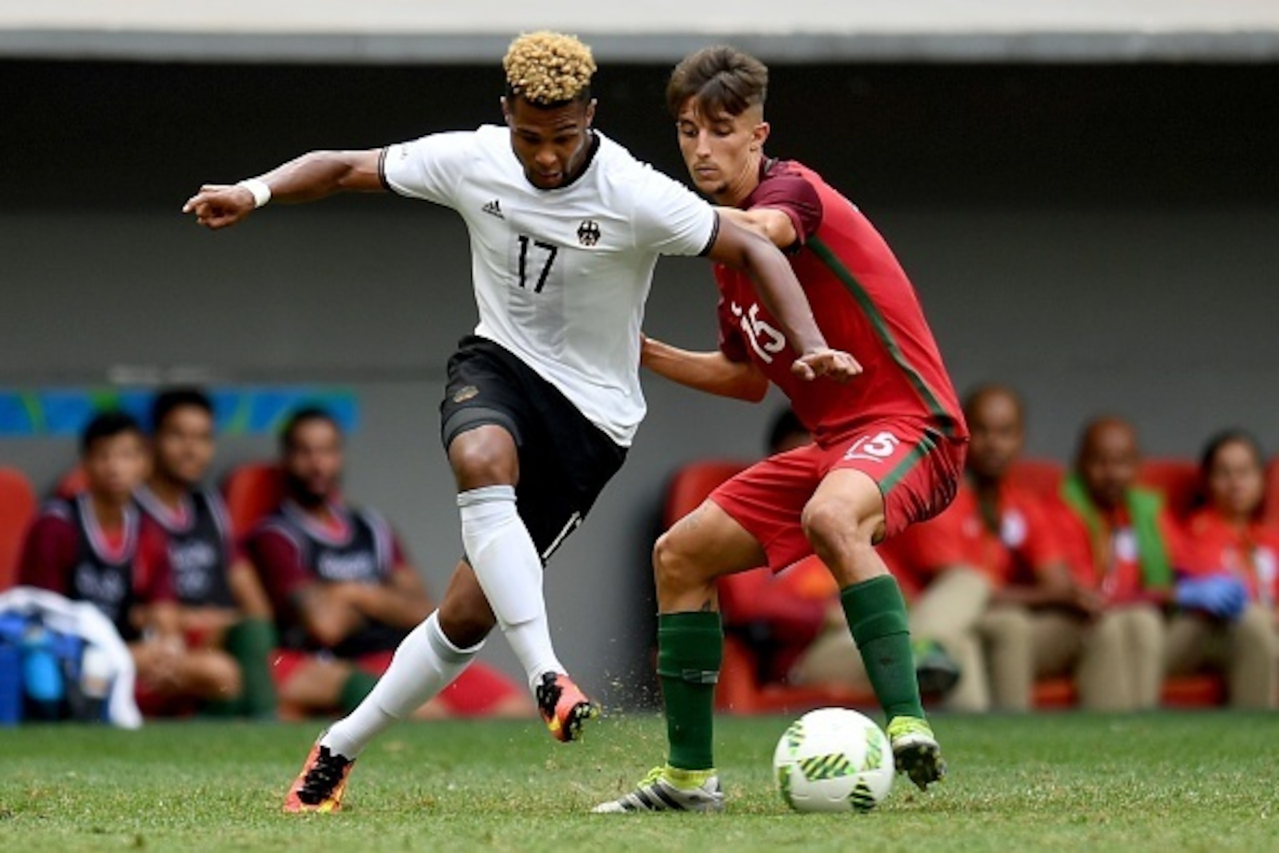 Germany's player Serge Gnabry (L) vies for the ball with Portugal's player Fernando during the Rio 2016 Olympic Games Quarter-finals men's football match Portugal vs Germany, at the Mane Garrincha Stadium in Brasilia on August 13, 2016. / AFP / EVARISTO S