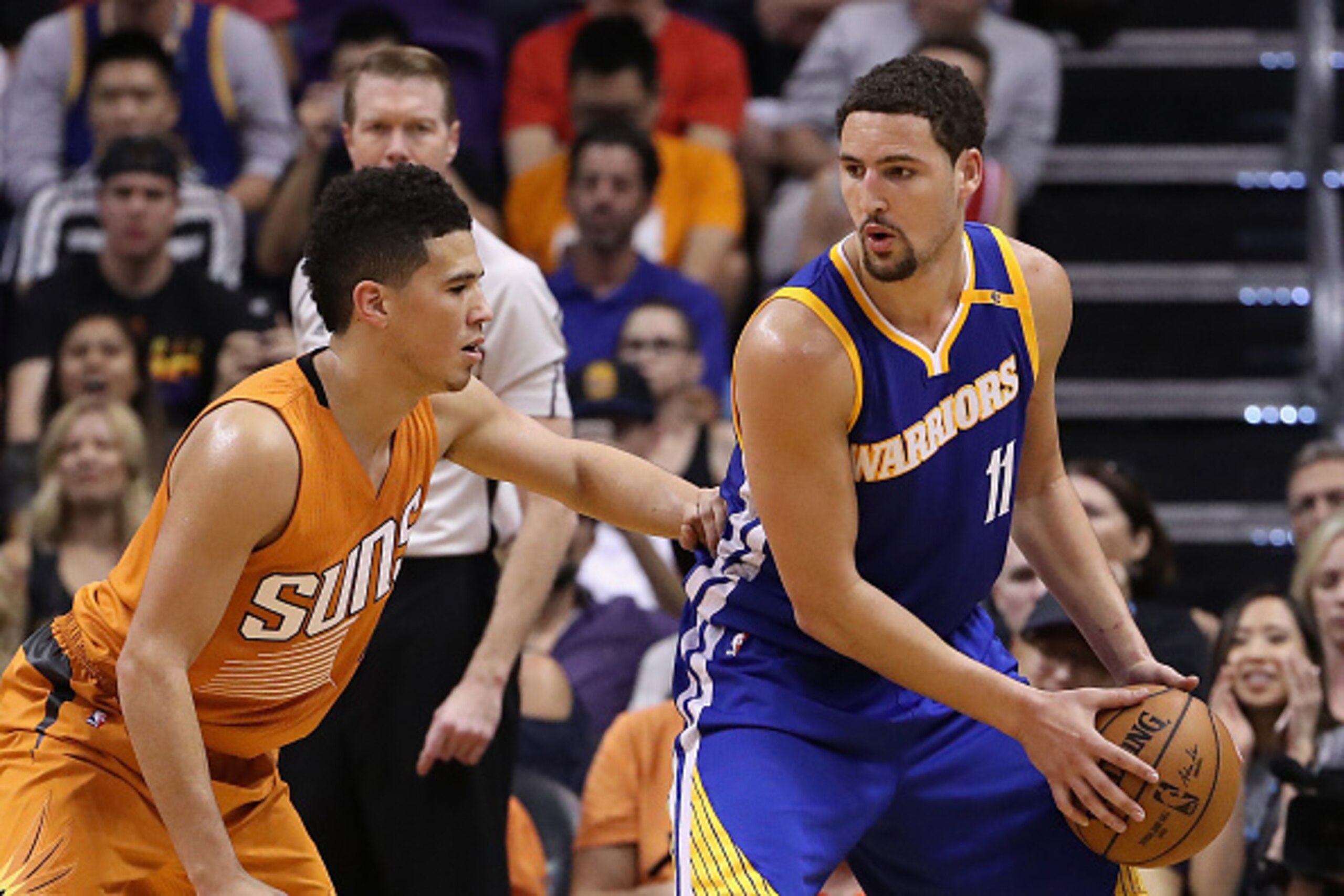 PHOENIX, AZ - OCTOBER 30: Klay Thompson #11 of the Golden State Warriors handles the ball guarded by Devin Booker #1 of the Phoenix Suns during the NBA game at Talking Stick Resort Arena on October 30, 2016 in Phoenix, Arizona. The Warriors defeated the PHOENIX, AZ - OCTOBER 30: Klay Thompson #11 of the Golden State Warriors handles the ball guarded by Devin Booker #1 of the Phoenix Suns during the NBA game at Talking Stick Resort Arena on October 30, 2016 in Phoenix, Arizona. The Warriors defeated the