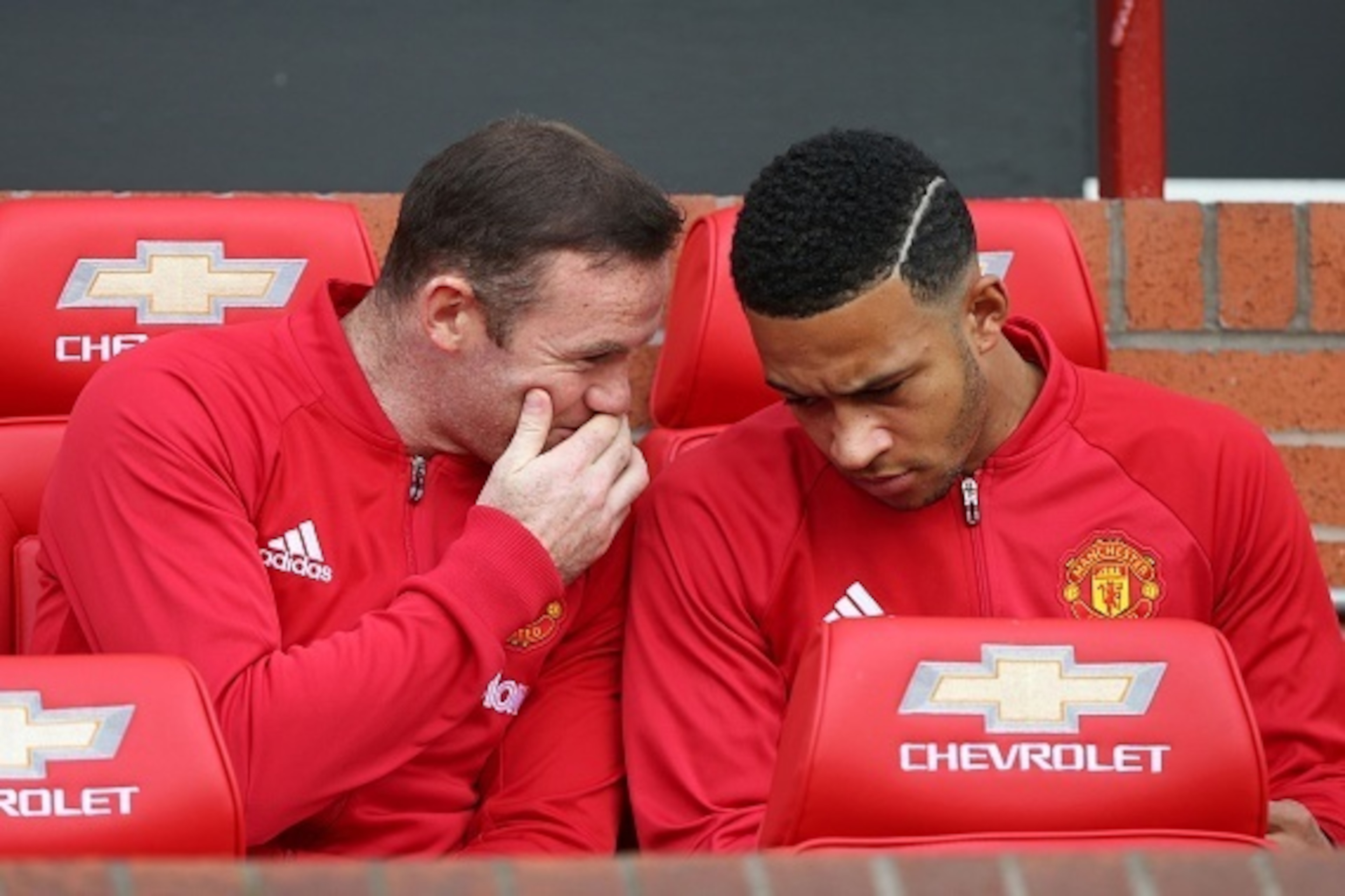 Substitute, Manchester United's English striker Wayne Rooney, talks to Manchester United's Dutch midfielder Memphis Depay (R) on the bench ahead of the English Premier League football match between Manchester United and Stoke City at Old Trafford in Manch