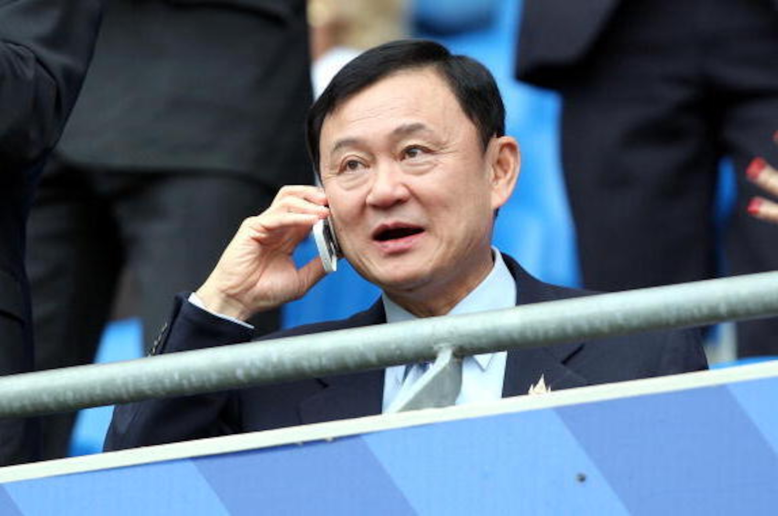 Manchester City's new Chairman Thaksin Shinawatra gives a phone call as he watches the pre-season Thomas Cook Trophy football match against Valencia at The City of Manchester Stadium in Manchester, north-west England, 04 August 2007.      AFP PHOTO / ANDR